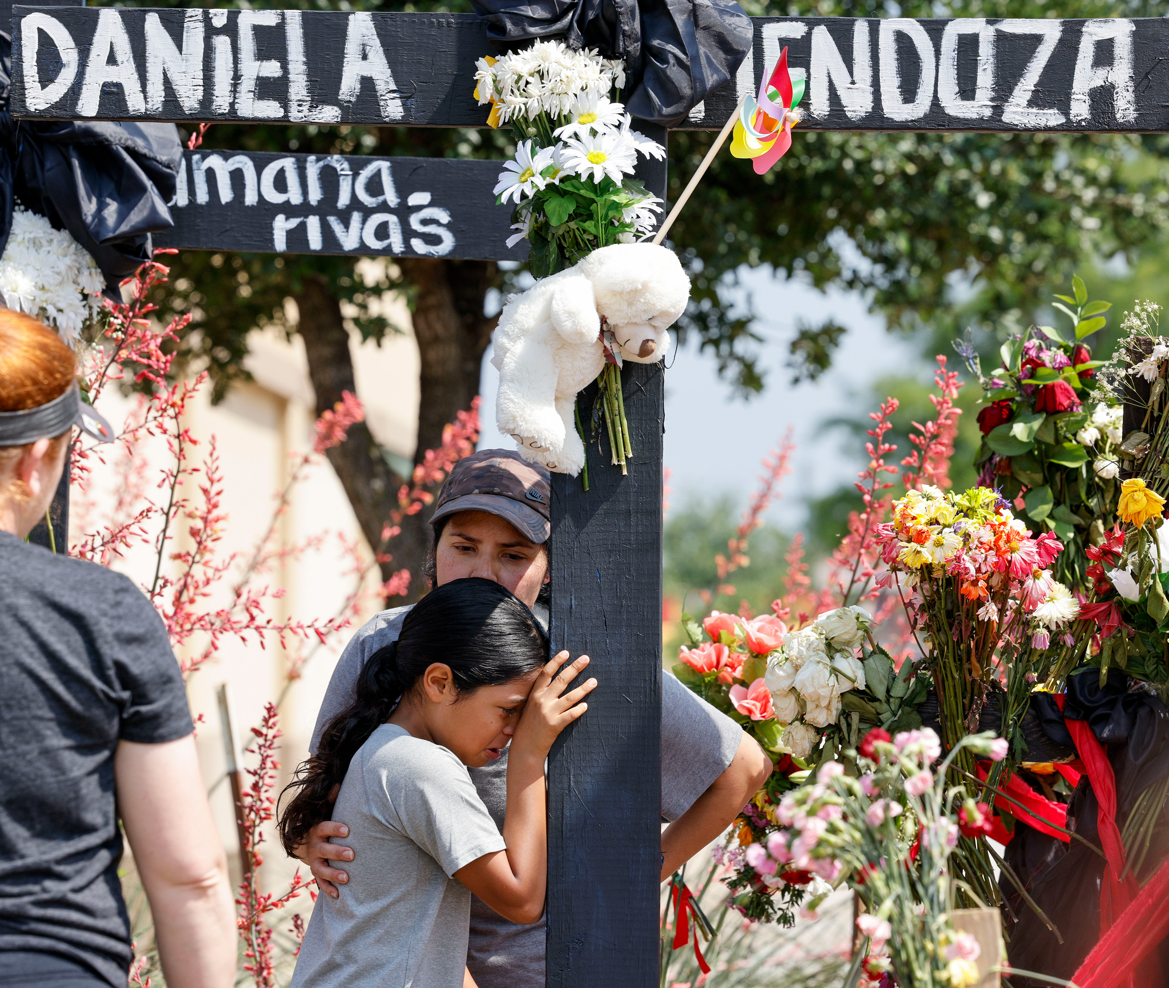 A woman, who did not wish to be identified, comforts a young girl who was friends with Allen Premium Outlets shooting victims Daniela Mendoza, 11, and Sofia Mendoza, 8, Tuesday, May 9, 2023, in Allen, Texas.