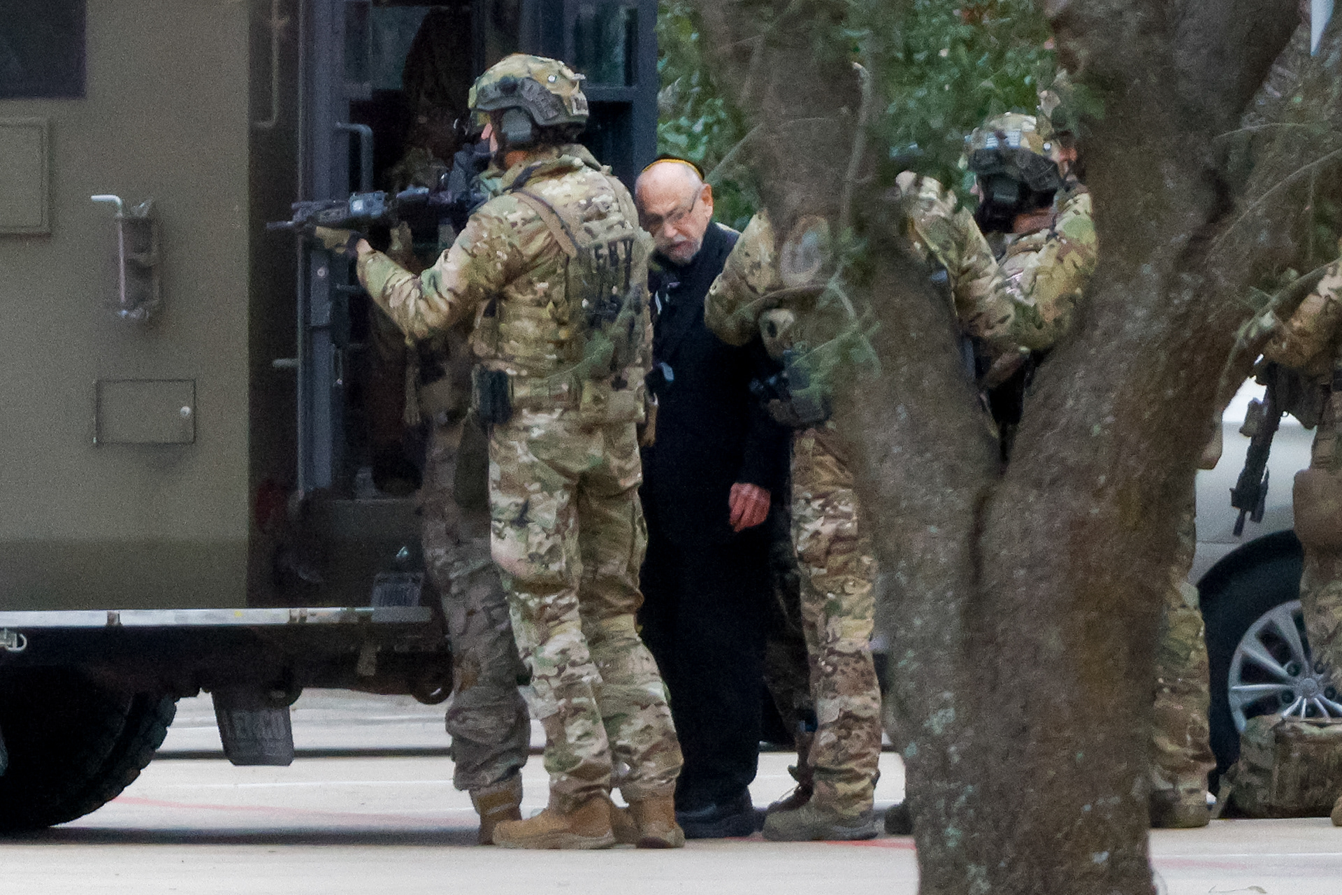 Members of the FBI escort a freed hostage while conducting SWAT operations at Congregation Beth Israel synagogue on Saturday, Jan. 15, 2022 in Colleyville, Texas. All four hostages were safe Saturday night after an 11-hour standoff inside a synagogue.