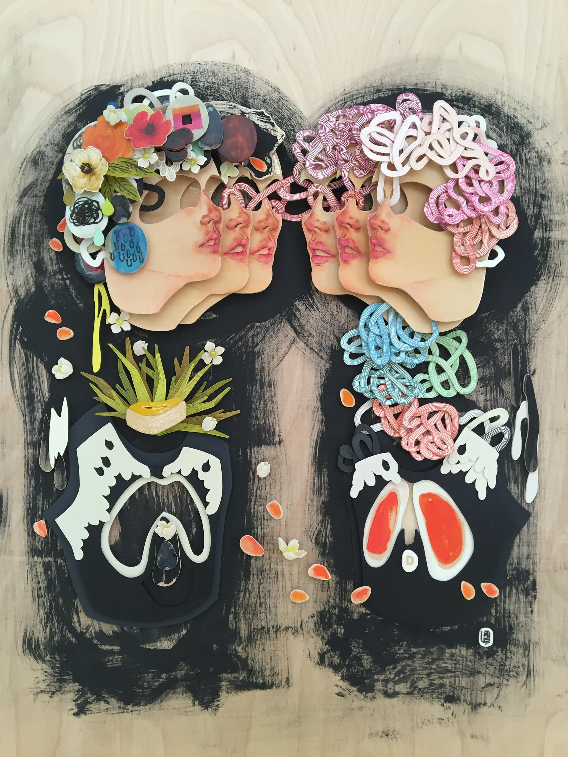 painting of wood pieces of two women with multiple faces, flowers, and design surround the body and face. Handcut wood on wood background