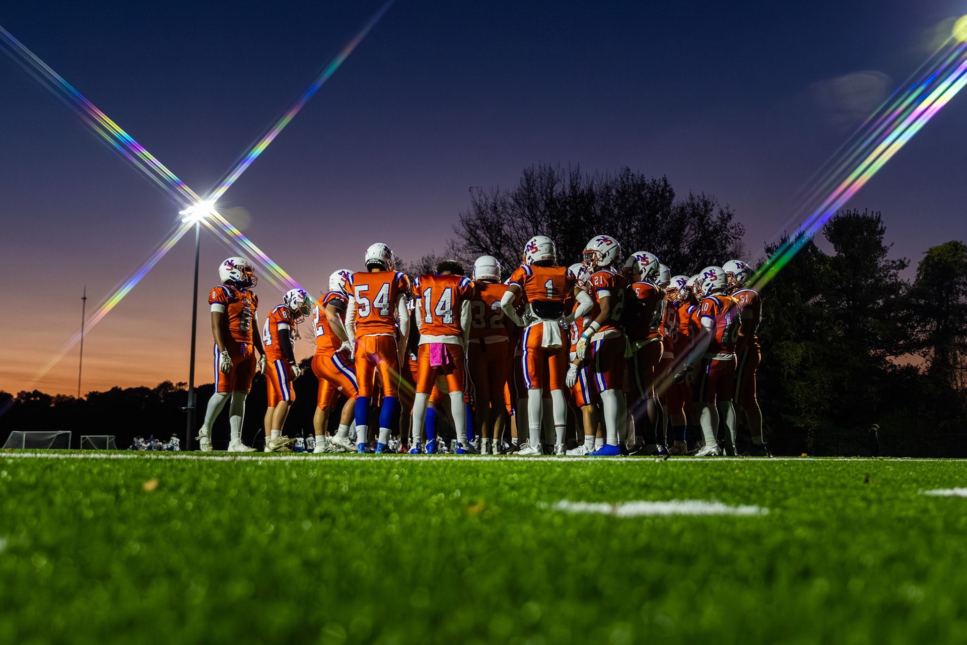 Newton South High School Varsity Football Team huddles under the lights on a Friday night. Shot on Canon R7. 10/18/2024
