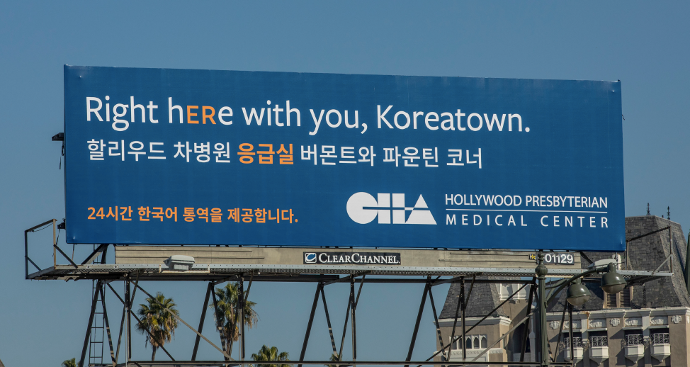 A photo of an emergency room billboard that says "right here with you, Koreatown."