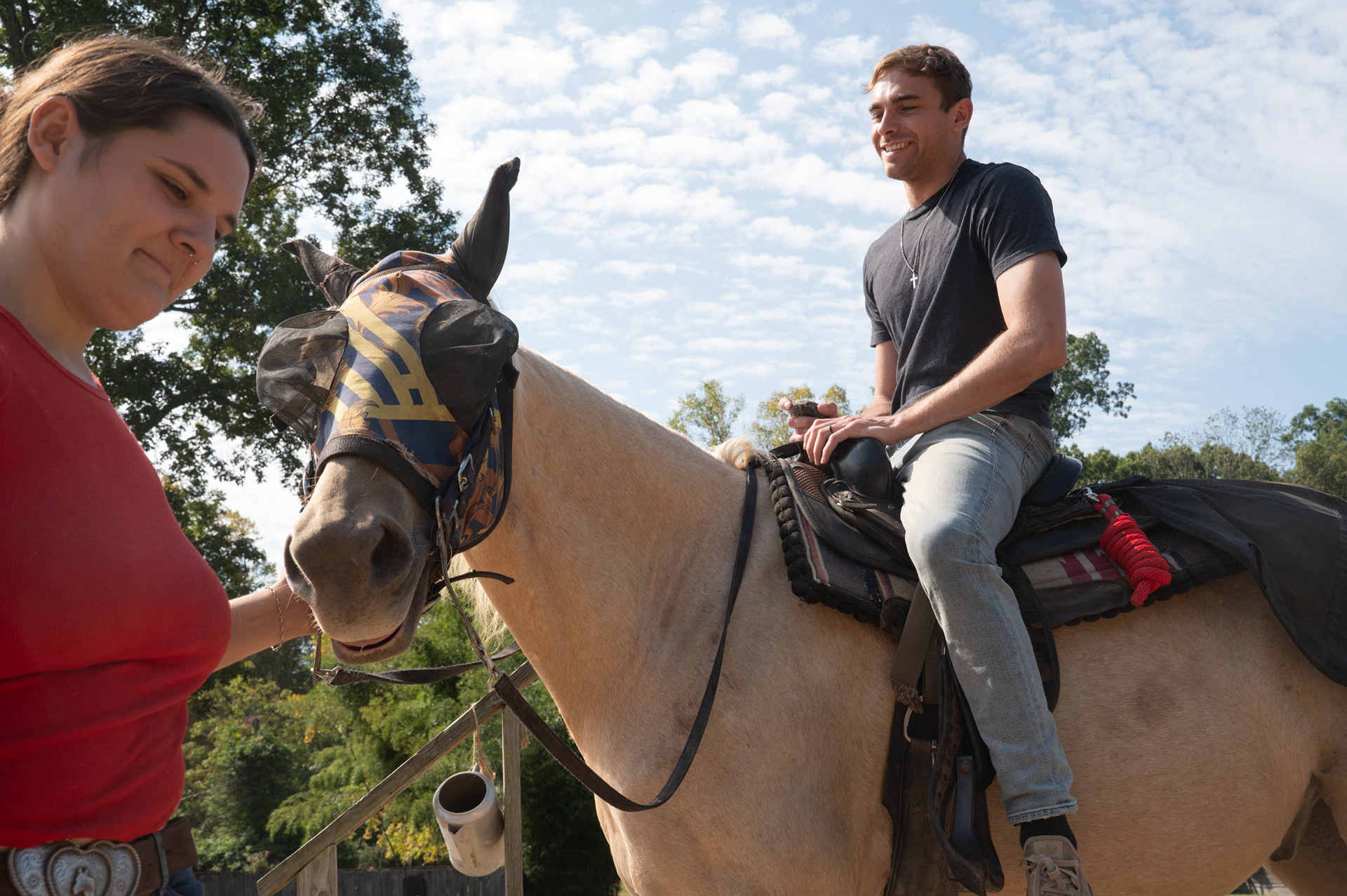 September 17, 2025, as Collin King mounts the horse assigned to him by his trail guide. Olivia Newman leads the horse Collin’s riding toward a hitching post; these posts are used before riders go out on trail allowing customers to comfortably get onto their designated horse.