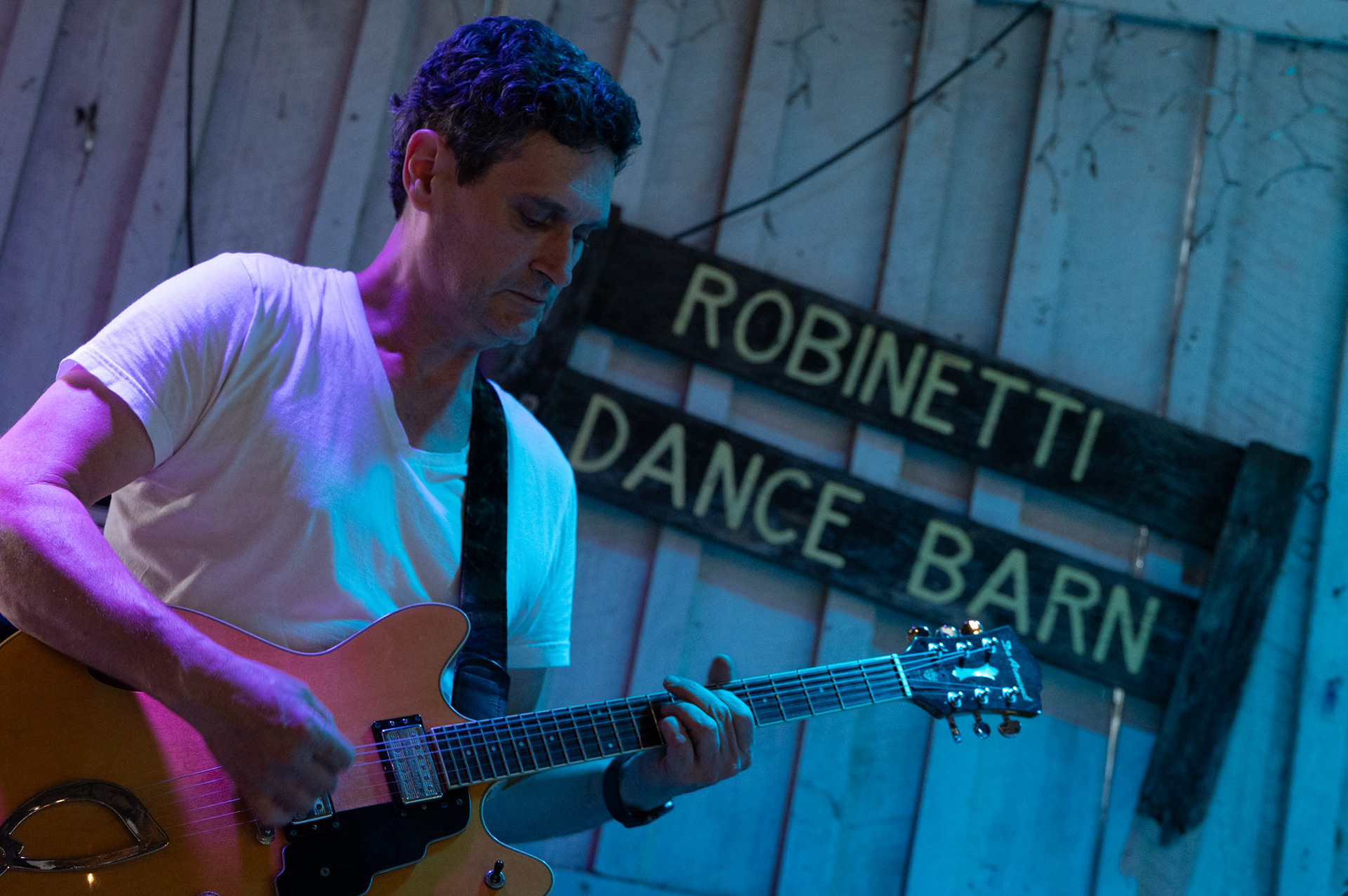 September 19th, 2025, Uncles Bucks dance barn, formerly named the Robinetti Dance Barn, Nick Collura shreds the guitar for his band Without Papers. While the crowds may not be large there is certainly a sense of community among those who come.