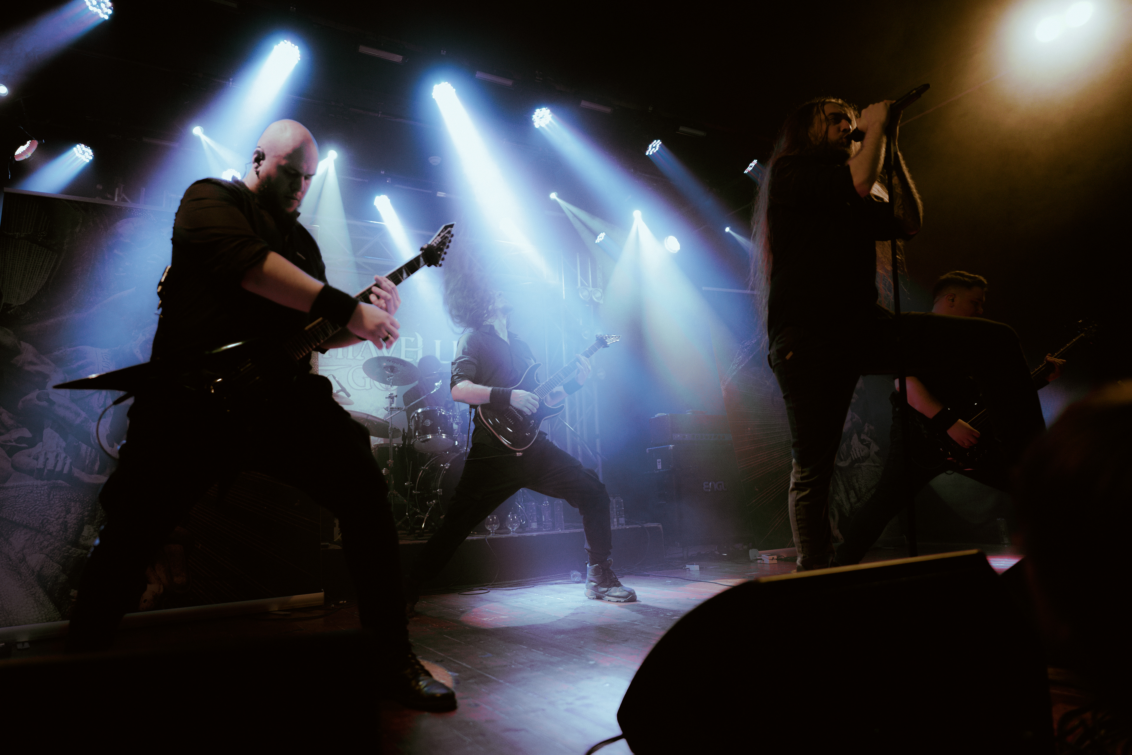 High-energy concert photography of all Machiavellian God members performing passionately on stage at Rockstadt Club, Brașov, Romania.