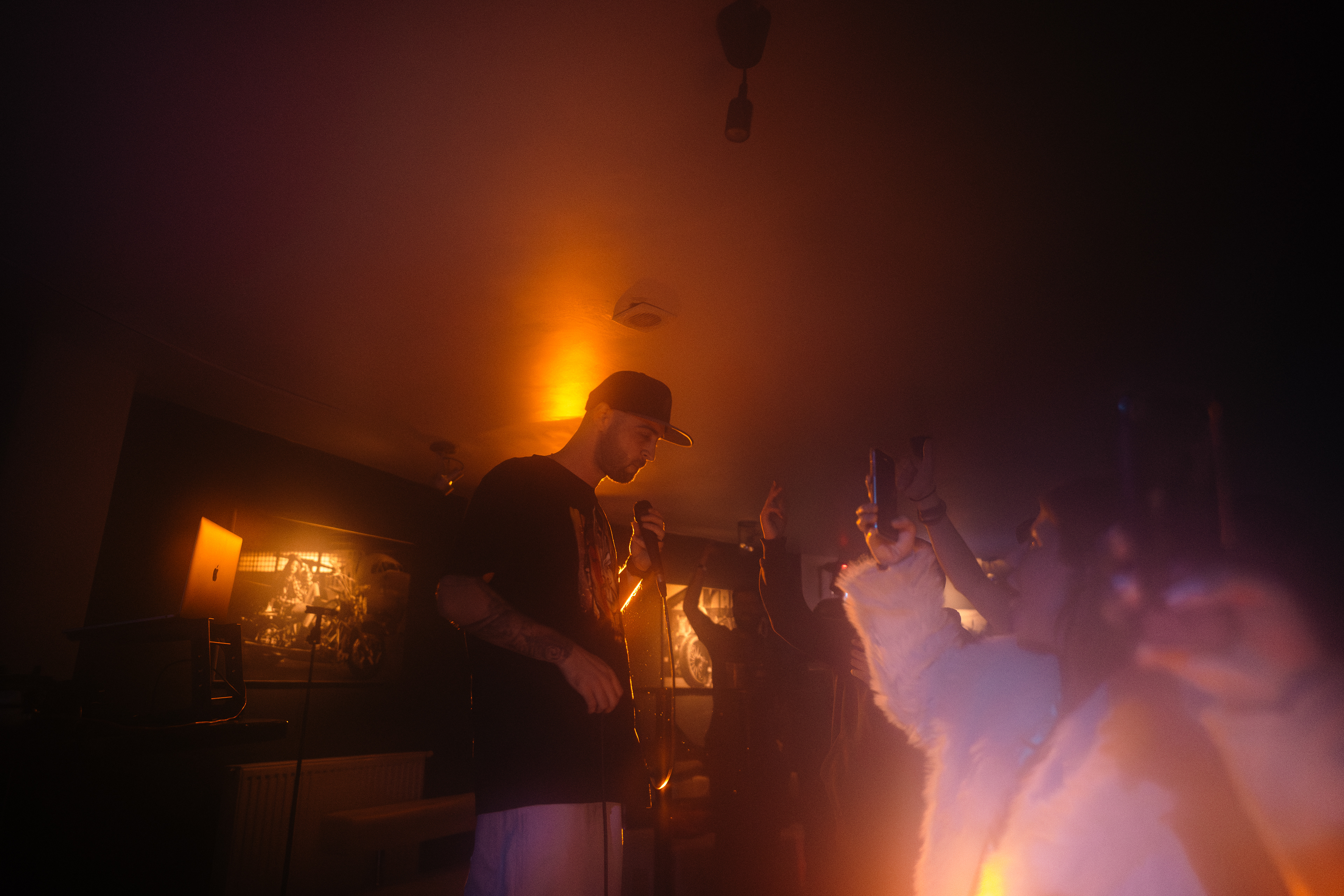 Close-up concert photography of Faust immersed in his performance, bathed in warm orange lighting at Motorpub in Brașov, Romania.