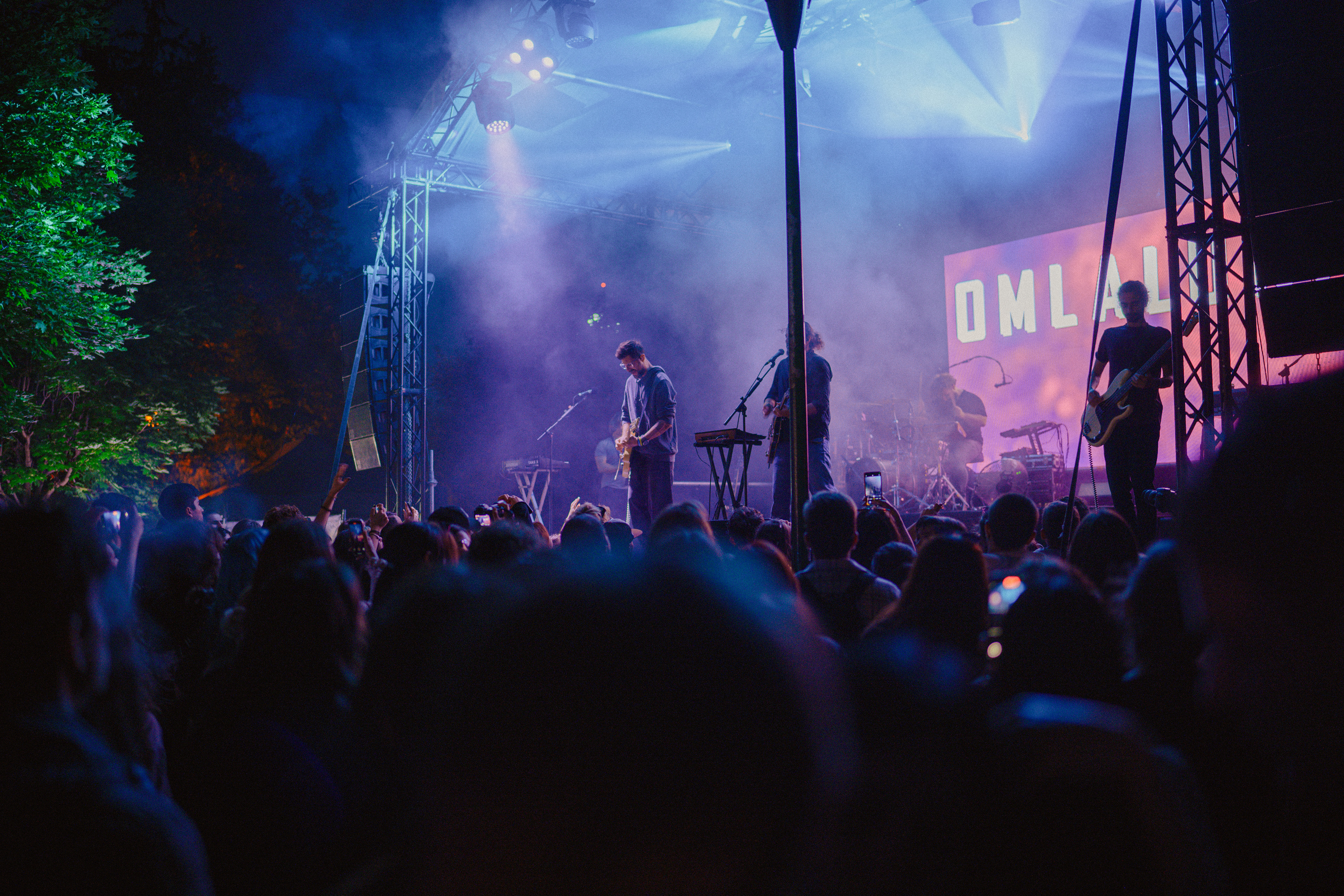 Live performance photography of Om La Luna’s guitarist playing expressively in front of the crowd.