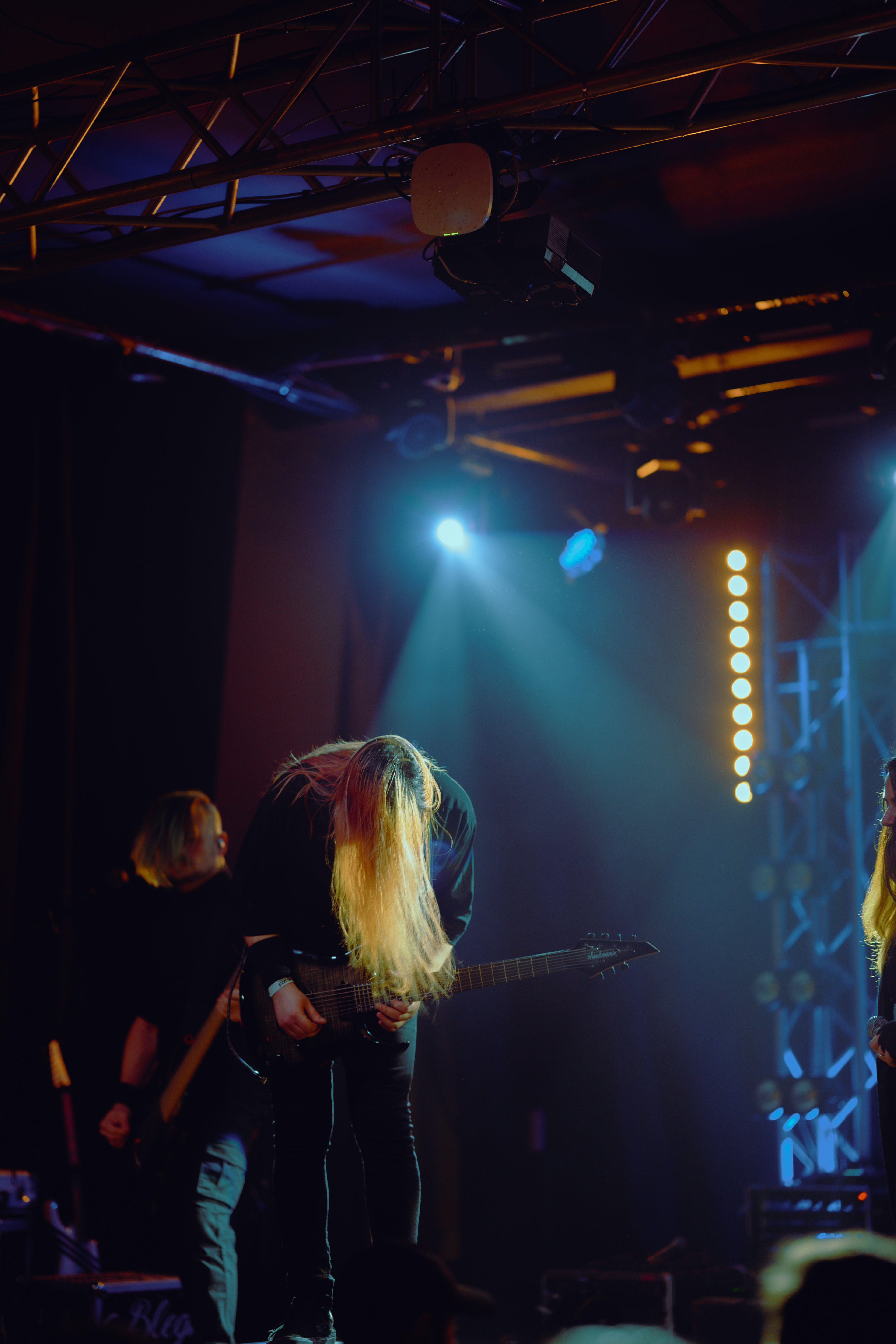 Silhouetted band members against a backdrop of flashing lights and thick smoke during a live set at Rockstadt Club in Brașov, Romania.