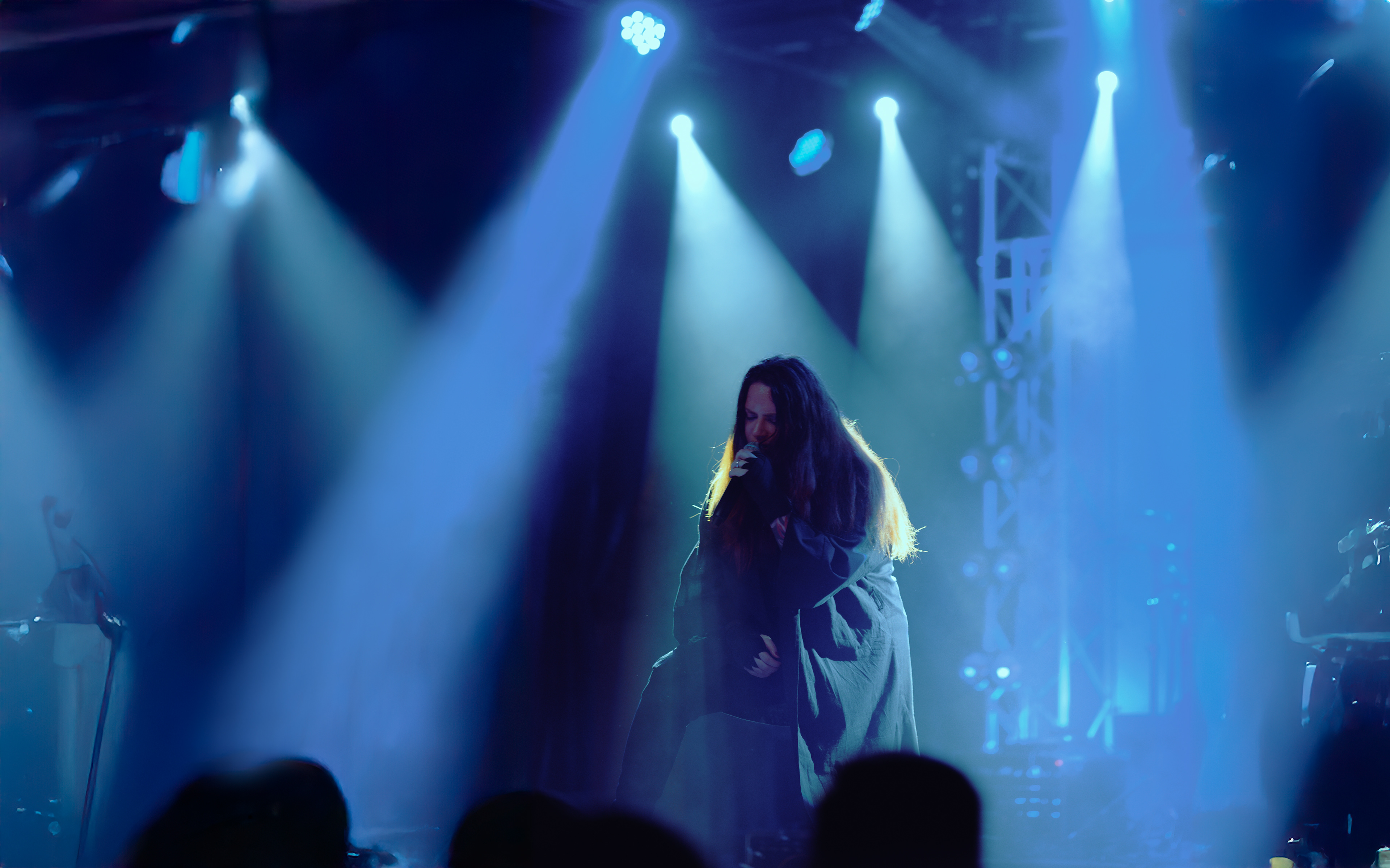 Band member engaging the audience, microphone in hand, in an intimate moment during the show at Rockstadt Club in Brașov, Romania.