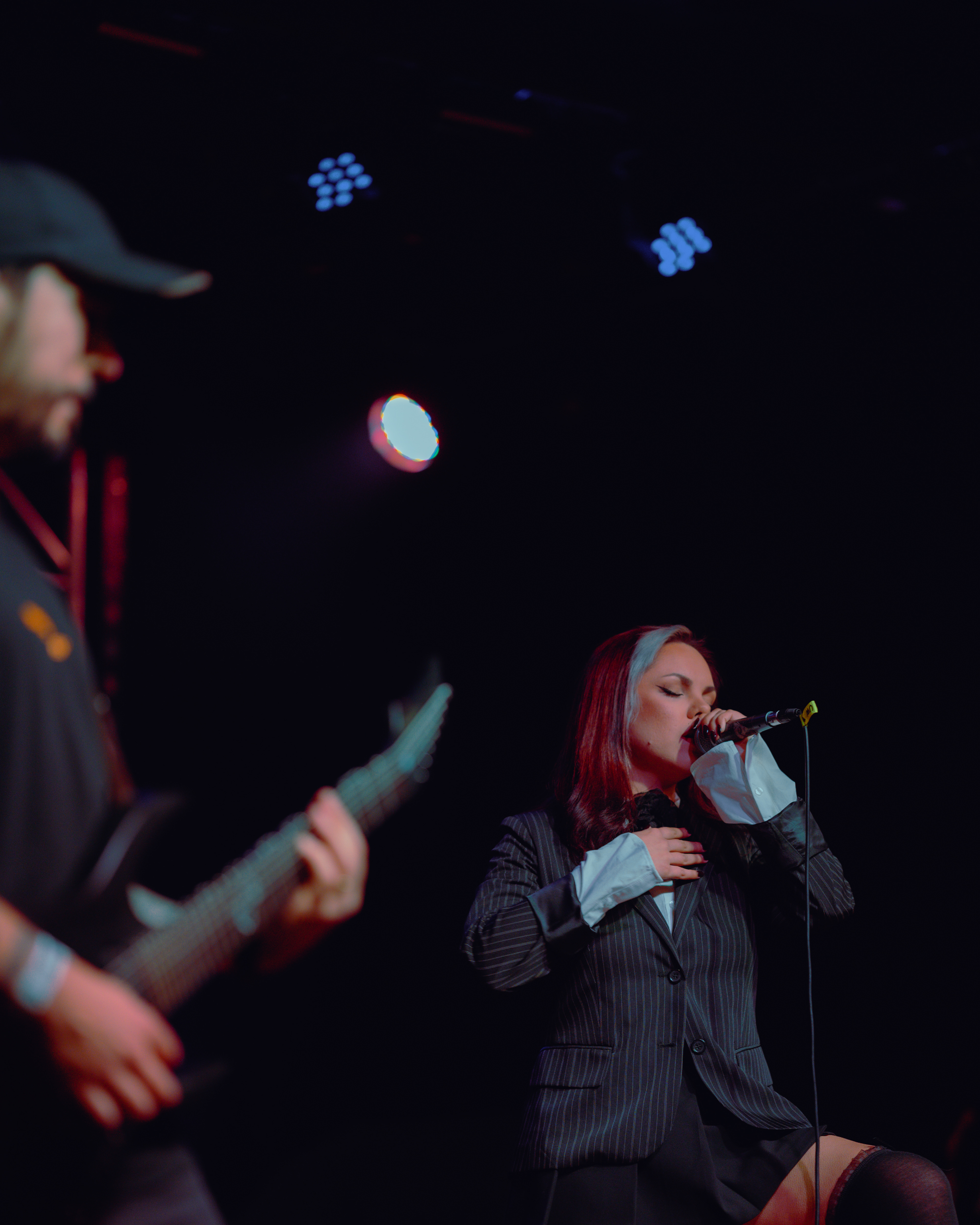Close-up of the Underwaves vocalist singing intensely into the microphone, eyes closed and fully immersed in the performance at Rockstadt Club in Brașov, Romania.