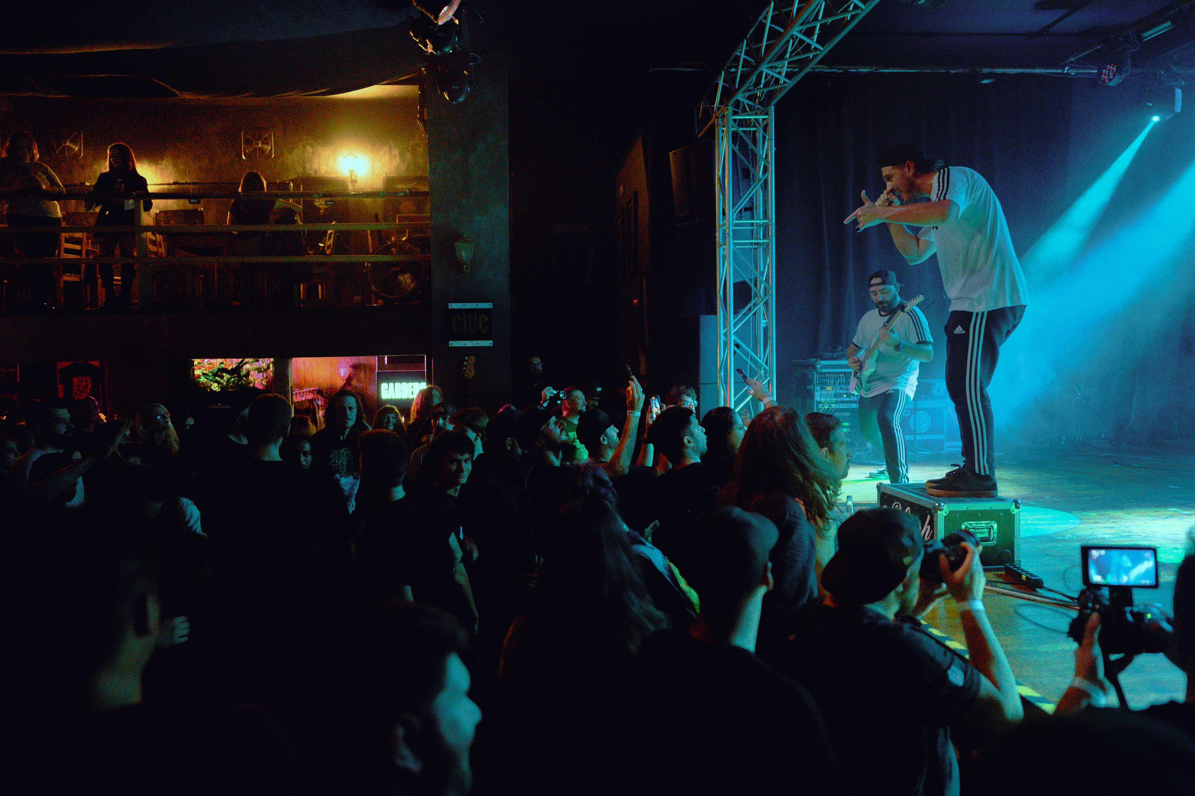 Concert photography of the vocalist of W3 4R3 NUM83R5 passionately engaging with the crowd, microphone extended toward fans at Rockstadt Club in Brașov, Romania.