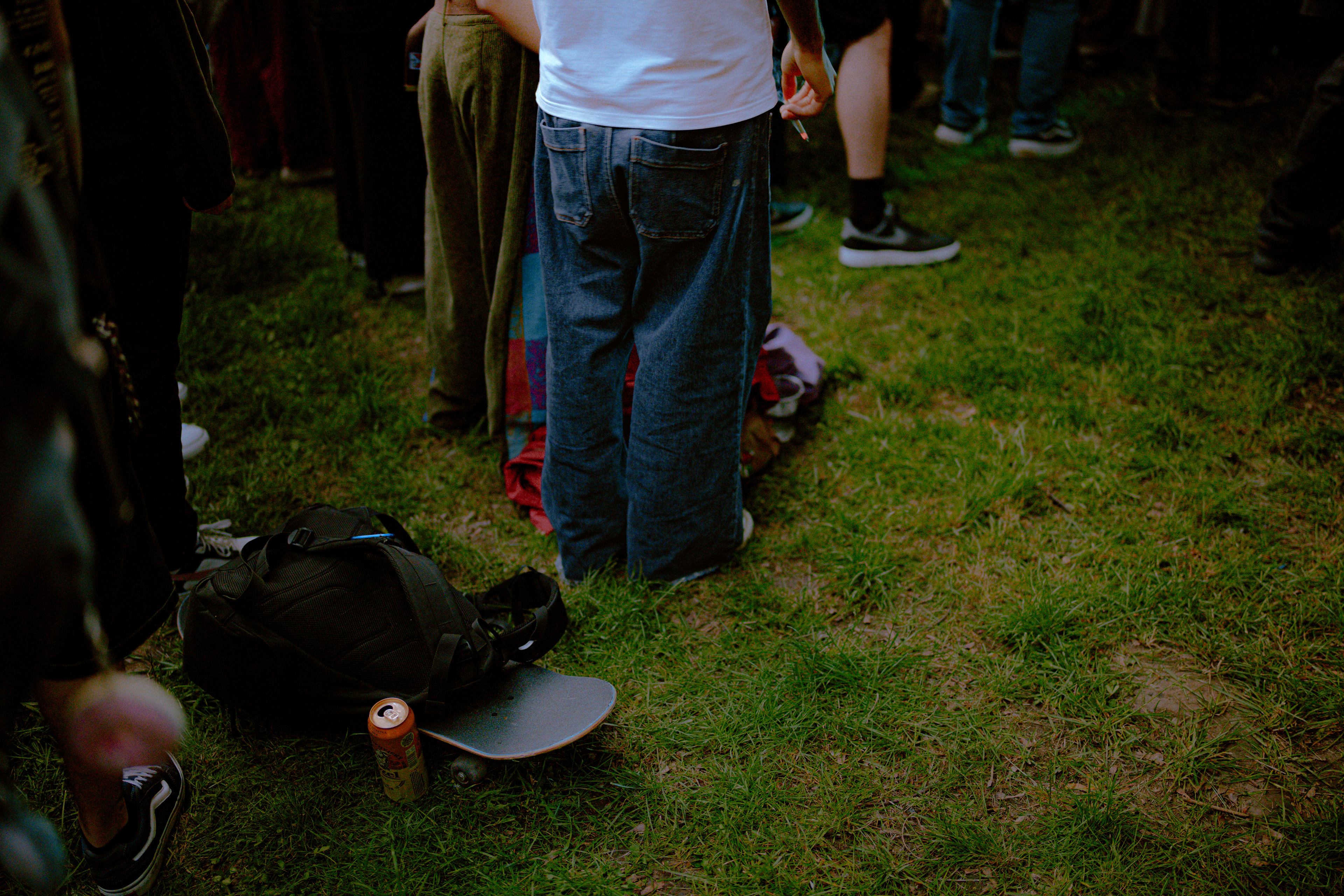 Documentary-style concert photography of a teenage couple with skateboards and beers enjoying the atmosphere at an Om La Luna live event.
