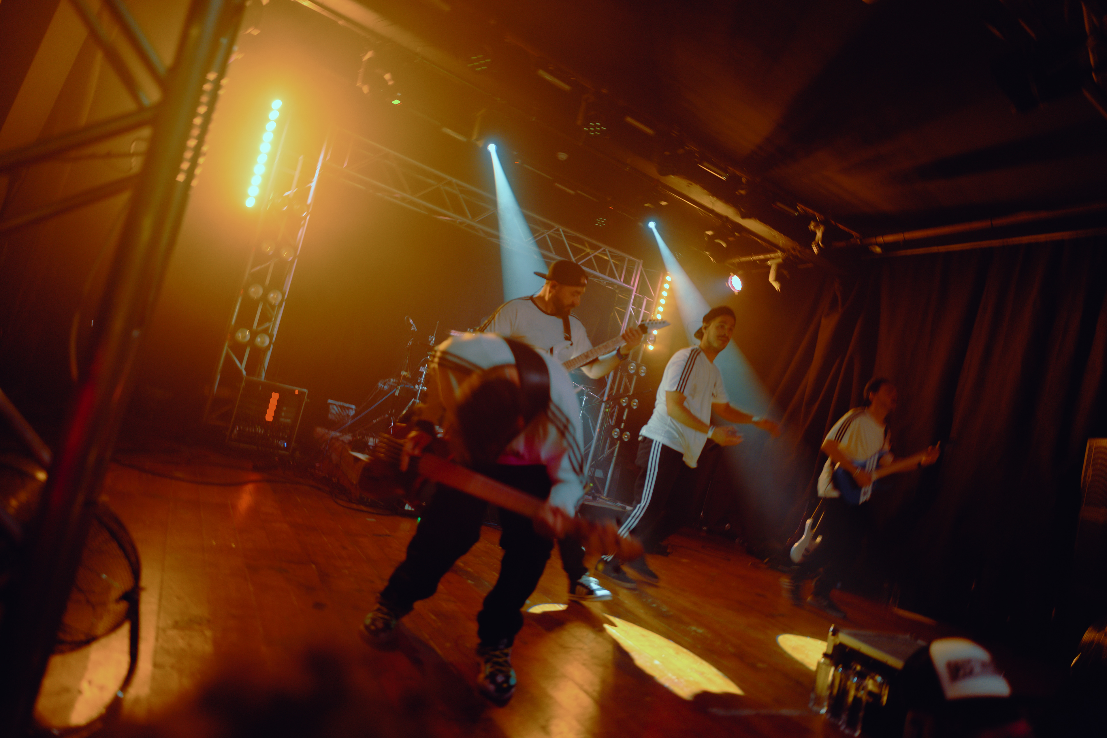 Dynamic concert photography of the bassist in mid-jump, caught in motion with fierce intensity while performing at Rockstadt Club in Brașov, Romania.