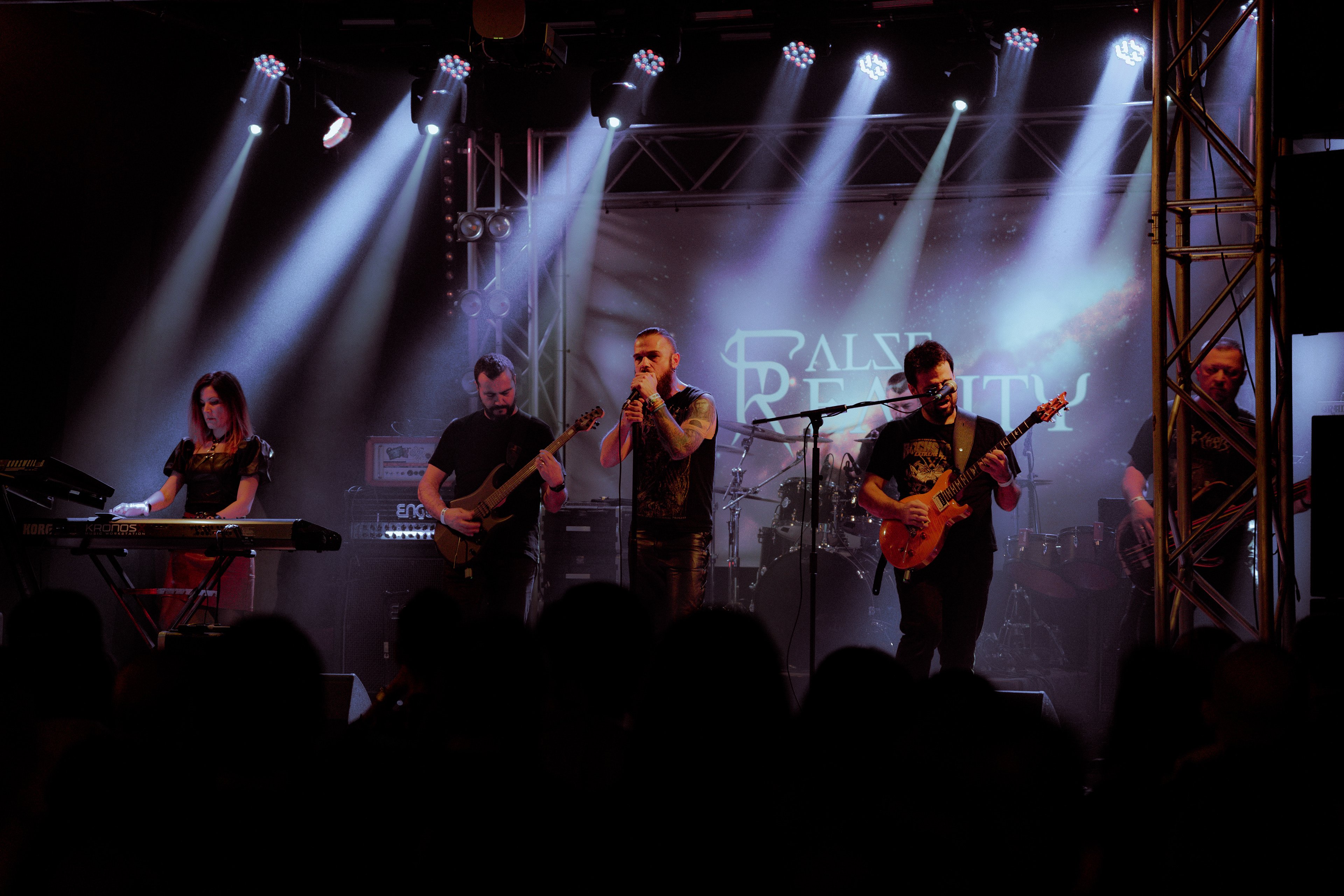 Wide-angle concert photography of all Flase Reality members performing together on stage at Rockstadt Club in Brașov, Romania.