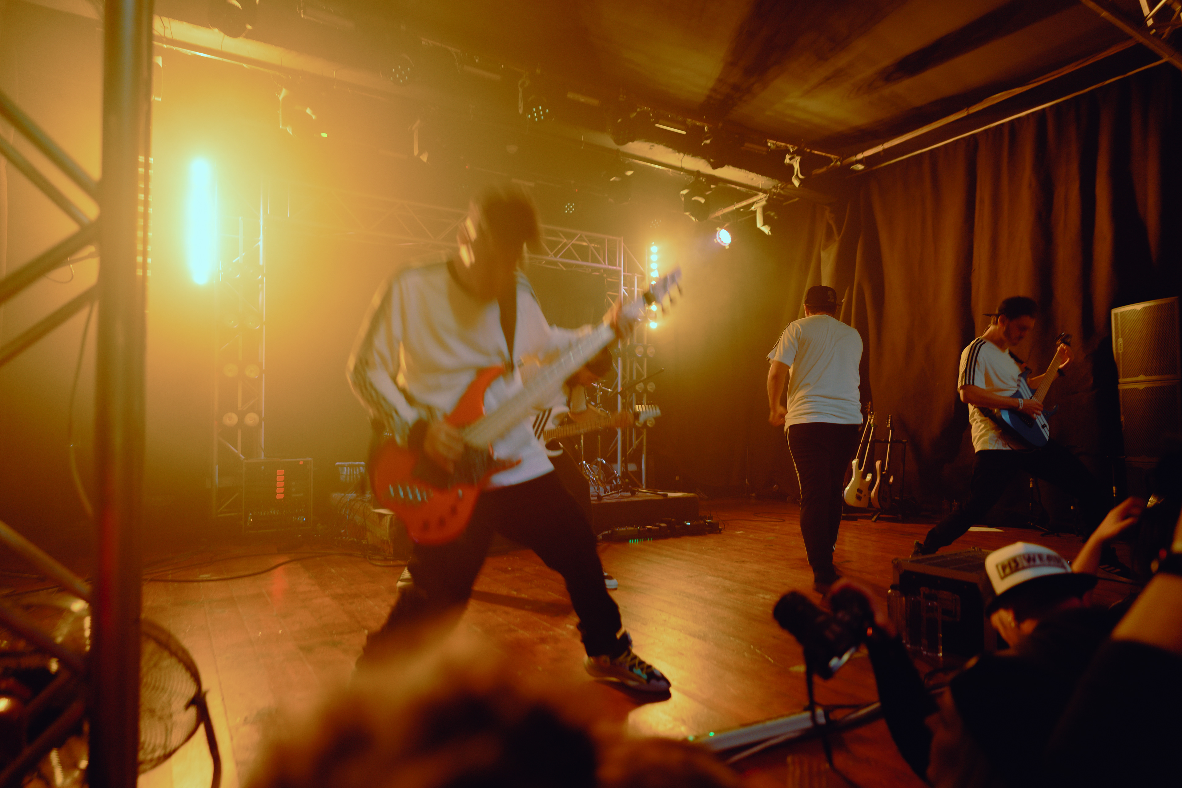 Concert photography capturing the bassist hard at work on stage, headbanging and immersed in the music at Rockstadt Club in Brașov, Romania.