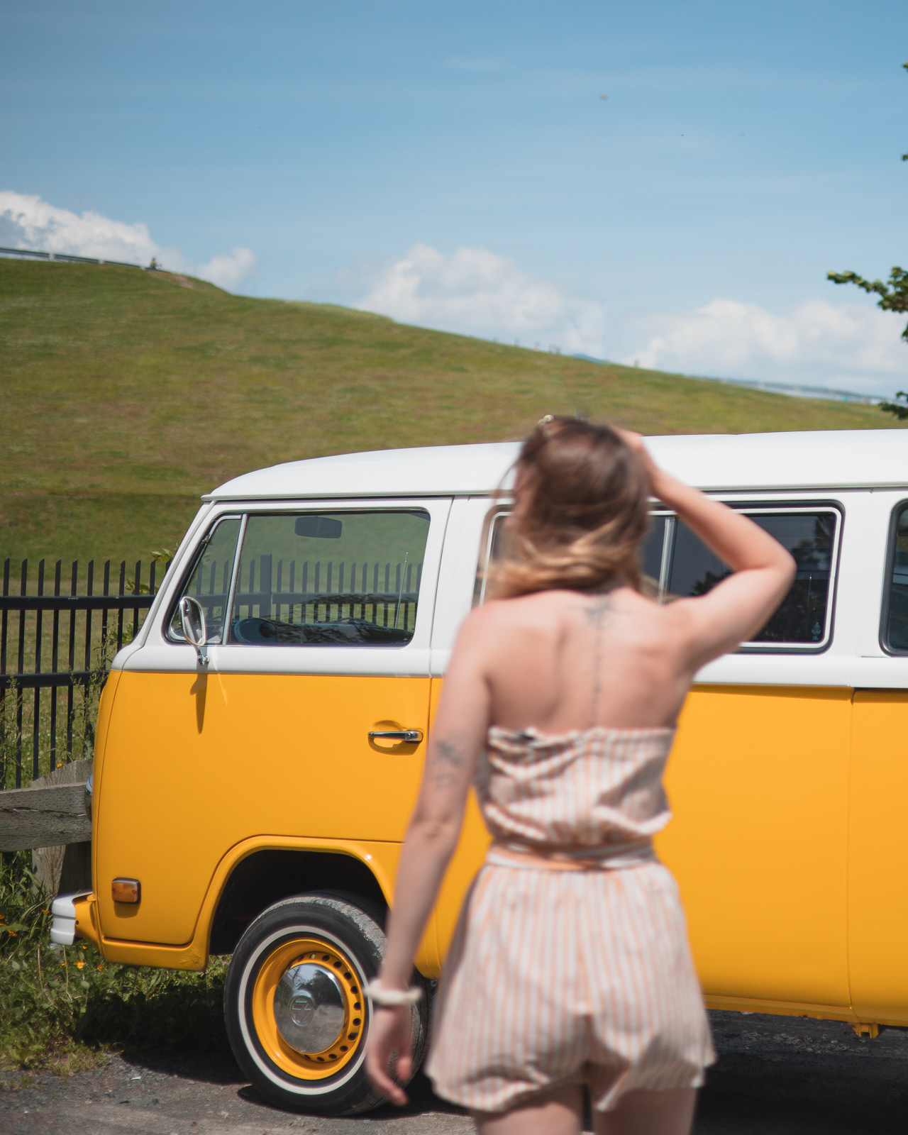 Woman standing in front of a yellow Volkswagen Westfalia camper in Halifax, Canada