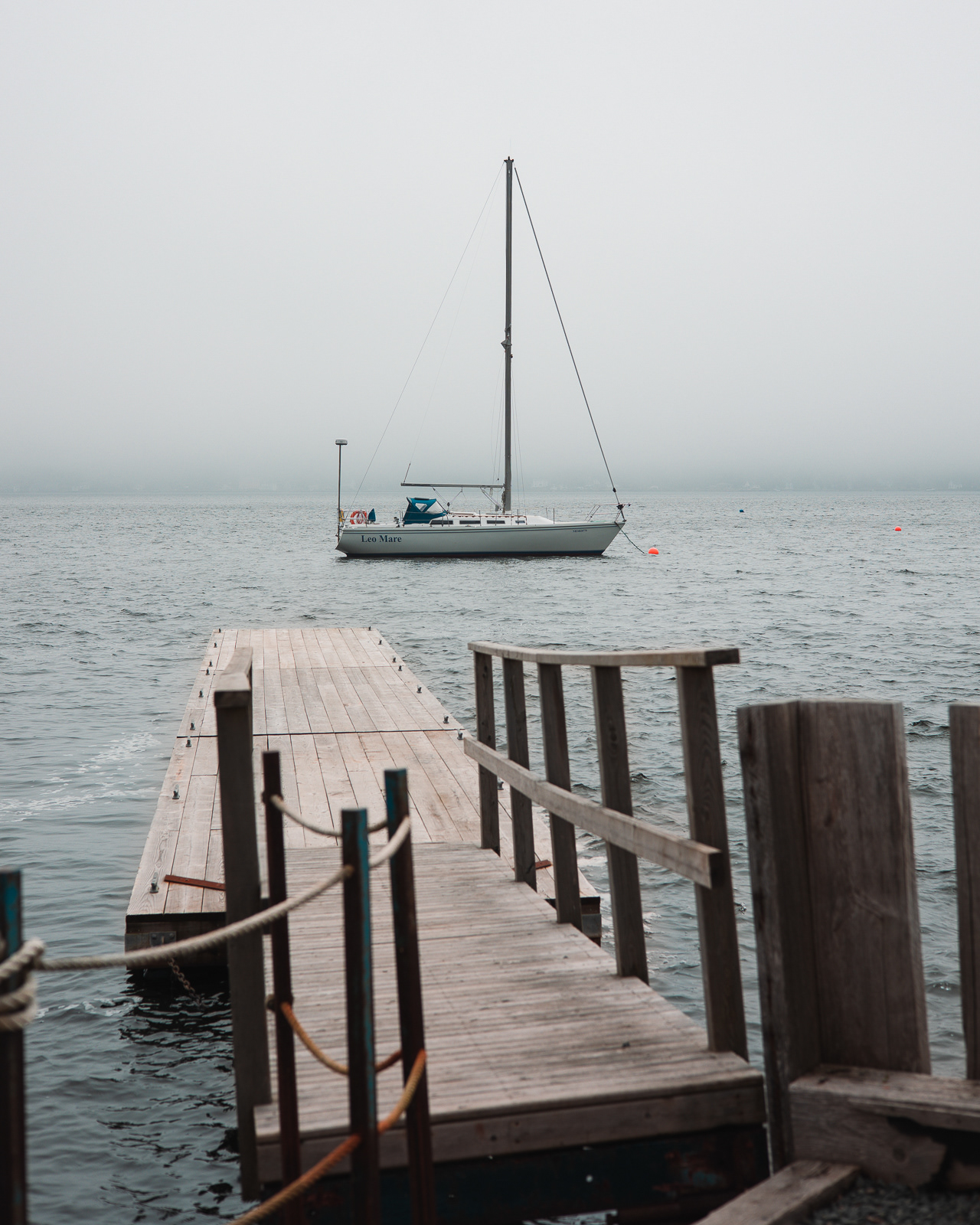 Sailboat anchored in a foggy bay in Nova Scotia, Canada