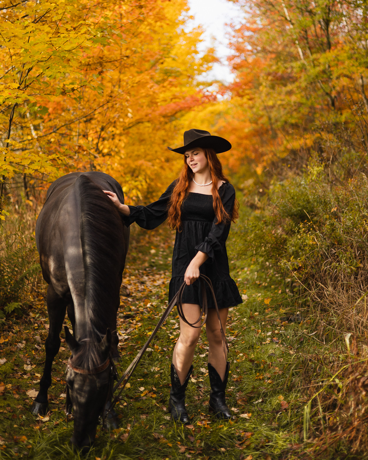 Portrait of a teenager with her horse in the forest