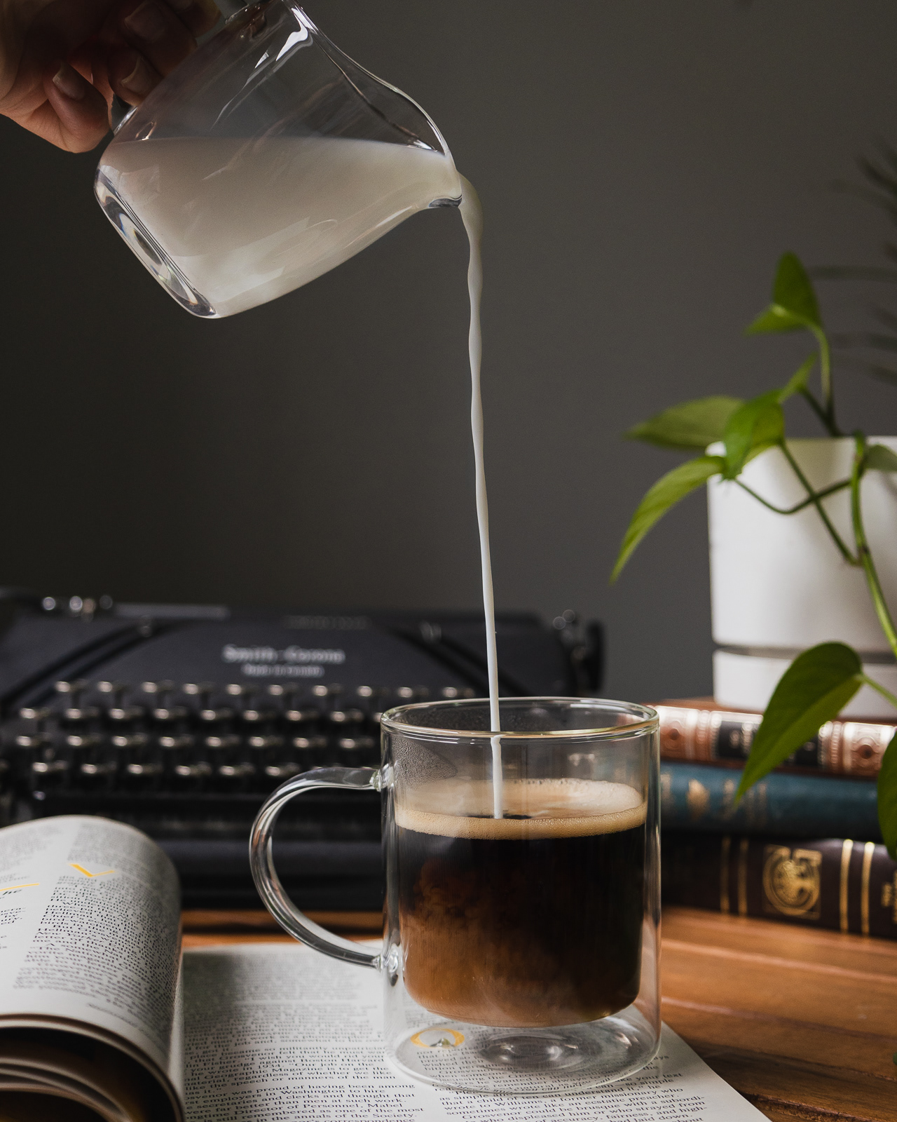 Hand pouring milk in a coffee cup for a product photoshoot