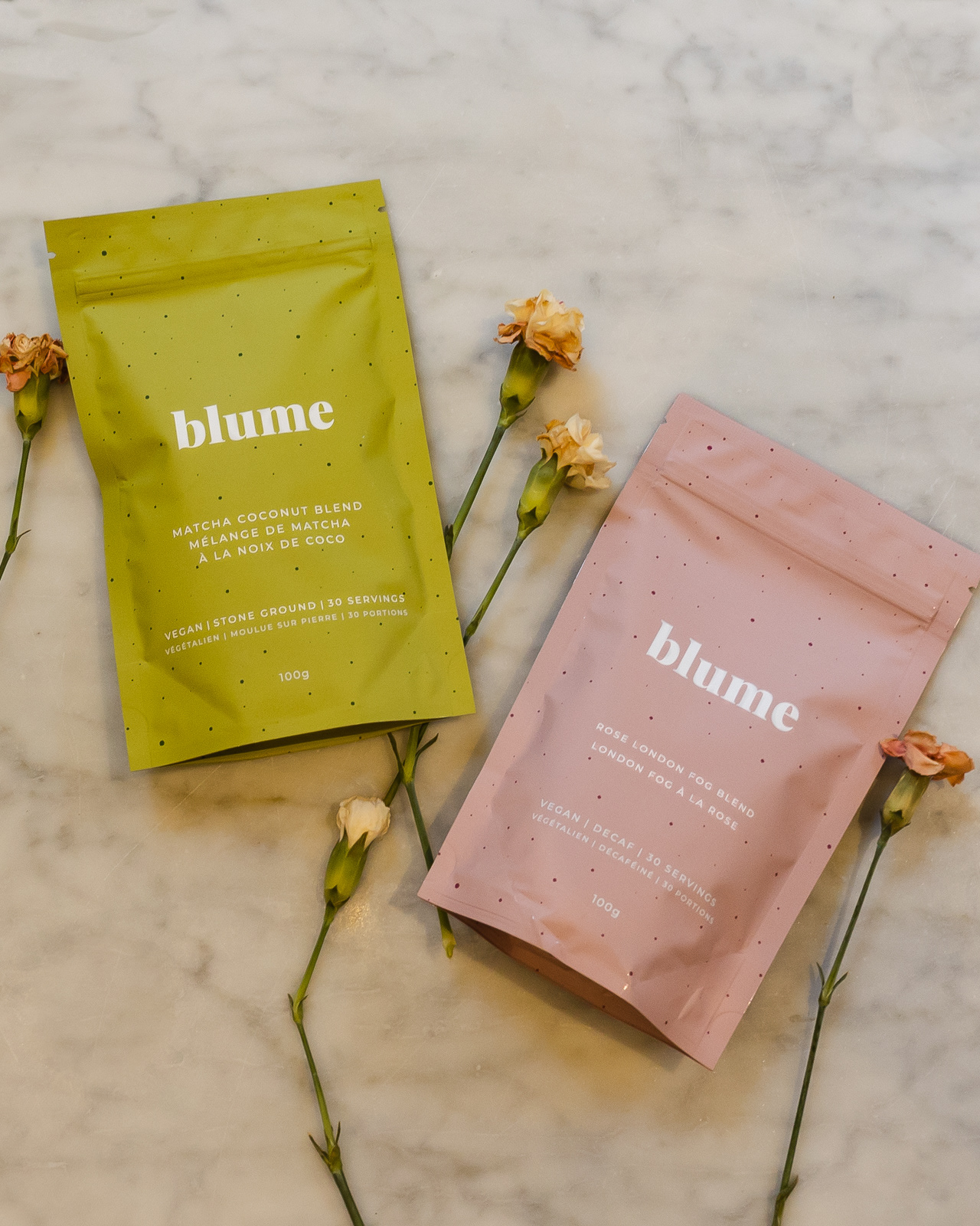Flatlay of two tea bags and flowers on a marble table