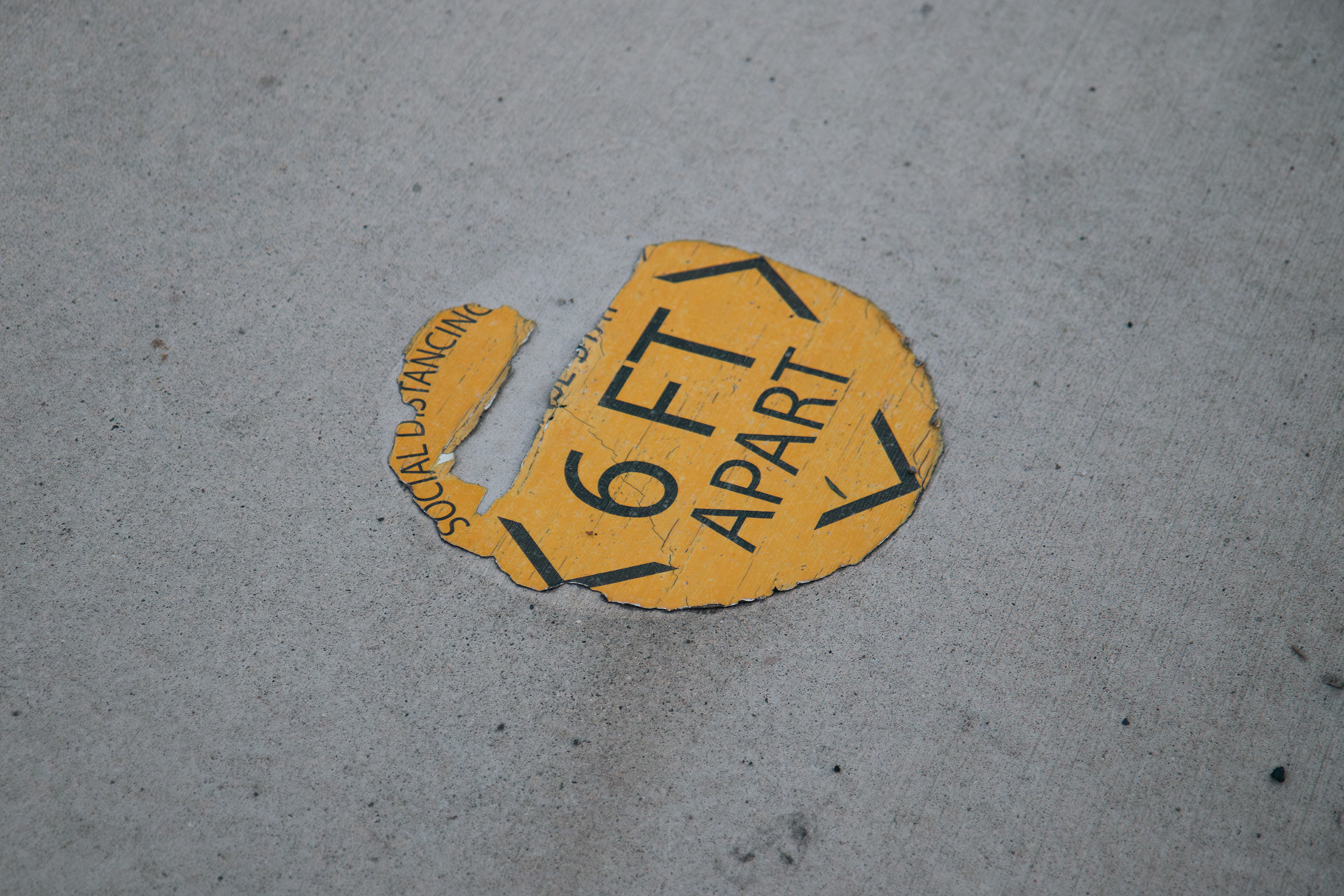 A social distancing sticker on the ground outside of the Burke Museum in Seattle, Wash. on Wednesday, October 25, 2023. The sticker is now deteriorated and hardly legible. (Photo by Chloe Sarmiento)
