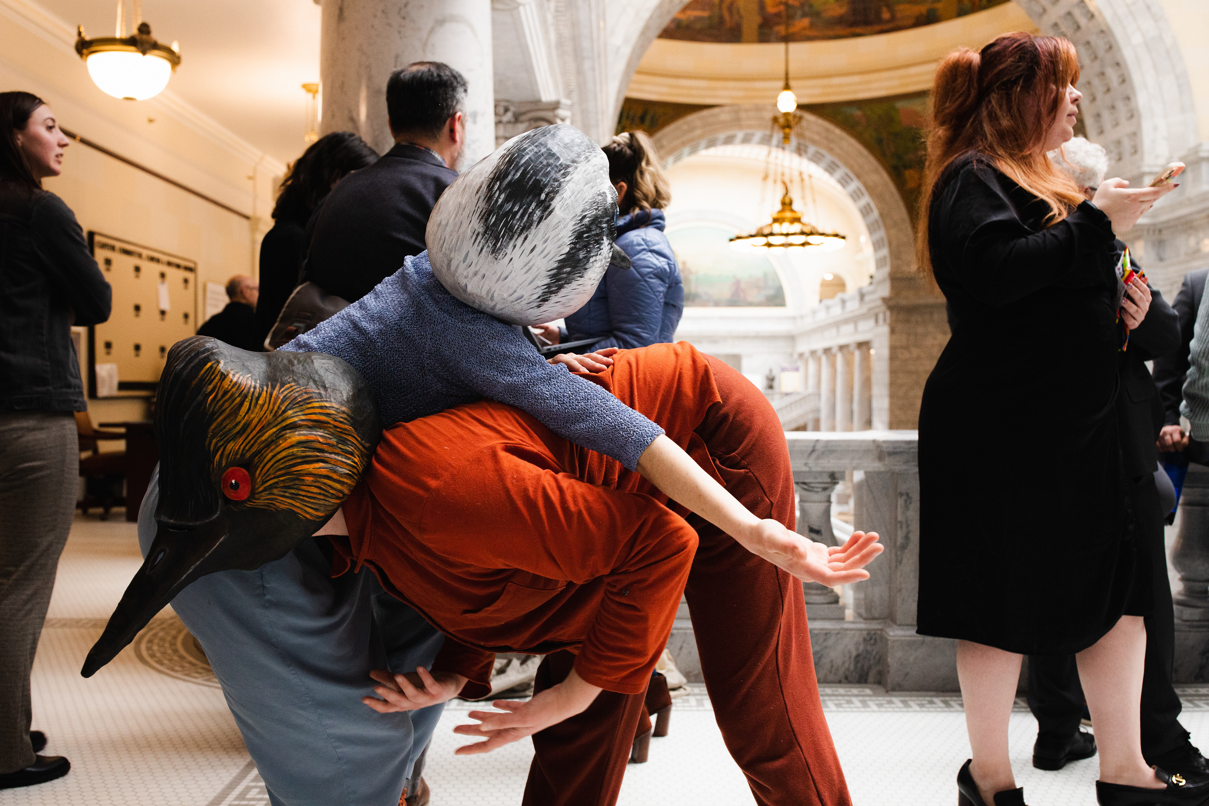 Sarah moves as Grebe in a piece performed at Utah's 2024 legislative session. Collaborators are Rae Luebbert and Bryn Watkins. Photo by Ash Gerlach. Masks by String and Shadow.