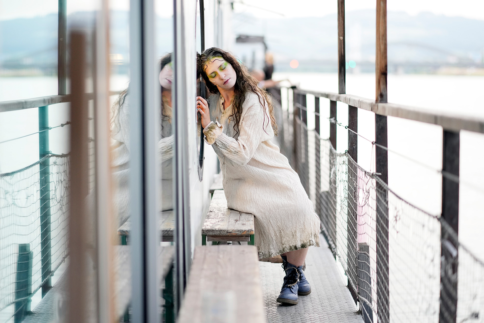 Die Irrfahrt der MS Florentine. Woman sitting outside of Salonschiff Florentine in Linz. 