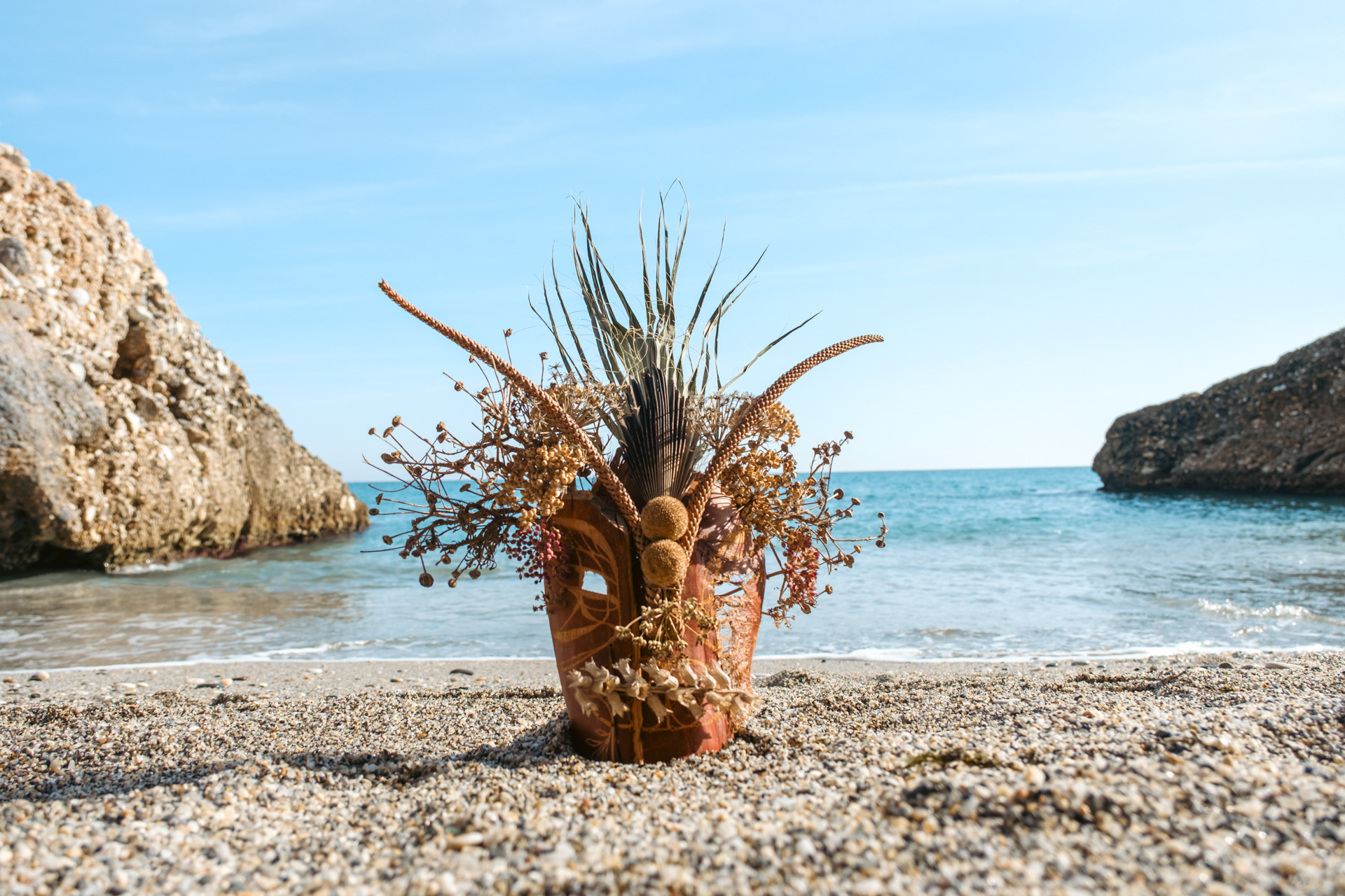 Anima-Maske am Strand mit Meereshorizont im Hintergrund