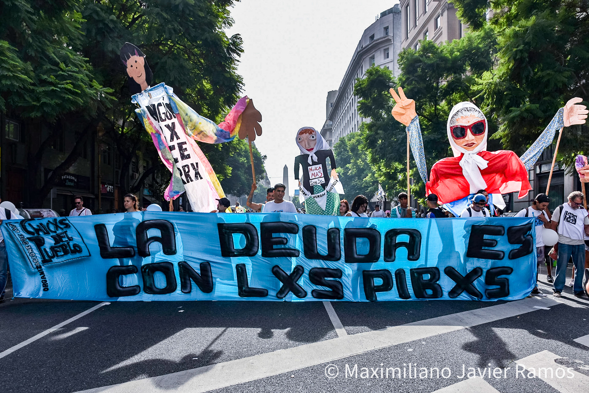 Un grupo de personas marchan por una de las principales avenidas de Buenos Aires con el Obelisco de fondo durante la marcha del Día de la Memoria. / A group of people march through one of the main avenues of Buenos Aires with the Obelisk in the background during the Remembrance Day march. / El Día Nacional de la Memoria por la Verdad y la Justicia es un día feriado inamovible de Argentina que se conmemora cada 24 de marzo. La fecha remite al golpe de Estado del 24 de marzo de 1976 y busca generar memoria y conciencia colectiva para que los golpes de Estado y las violaciones de derechos humanos no se repitan "nunca más" y sus autores sean enjuiciados y castigados. El Proceso de Reorganización Nacional fue una dictadura cívico-militar que causó que decenas de miles de personas fueran asesinadas, desaparecidas, violadas, torturadas, secuestradas siendo bebés, o debieran nacer en cautiverio, padecer la sustracción de su identidad y sufrir el exilio. Las organizaciones de derechos humanos, los sindicatos, el movimiento estudiantil, los movimientos sociales y muchos partidos políticos hacen referencia a los 30 000 desaparecidos,1 que fueron víctimas de la última dictadura y cuya presencia en la sociedad actual se invoca en cada conmemoración al grito “30.000 detenidos-desaparecidos ¡Presentes! ¡Ahora y siempre!” The National Day of Memory for Truth and Justice is an immovable holiday in Argentina that is commemorated every March 24. The date refers to the coup d'état of March 24, 1976 and seeks to generate memory and collective awareness so that coups d'état and human rights violations are not repeated "never again" and their perpetrators are prosecuted and punished. The National Reorganization Process was a civil-military dictatorship that caused tens of thousands of people to be killed, disappeared, raped, tortured, kidnapped as babies, or had to be born in captivity, suffer theft of their identity and suffer exile. Human rights organizations, trade unions, the student movement, social movements and many political parties refer to the 30,000 disappeared,1 who were victims of the last dictatorship and whose presence in today's society is invoked in every shouted commemoration “30,000 detained-disappeared Present! Now and always!"