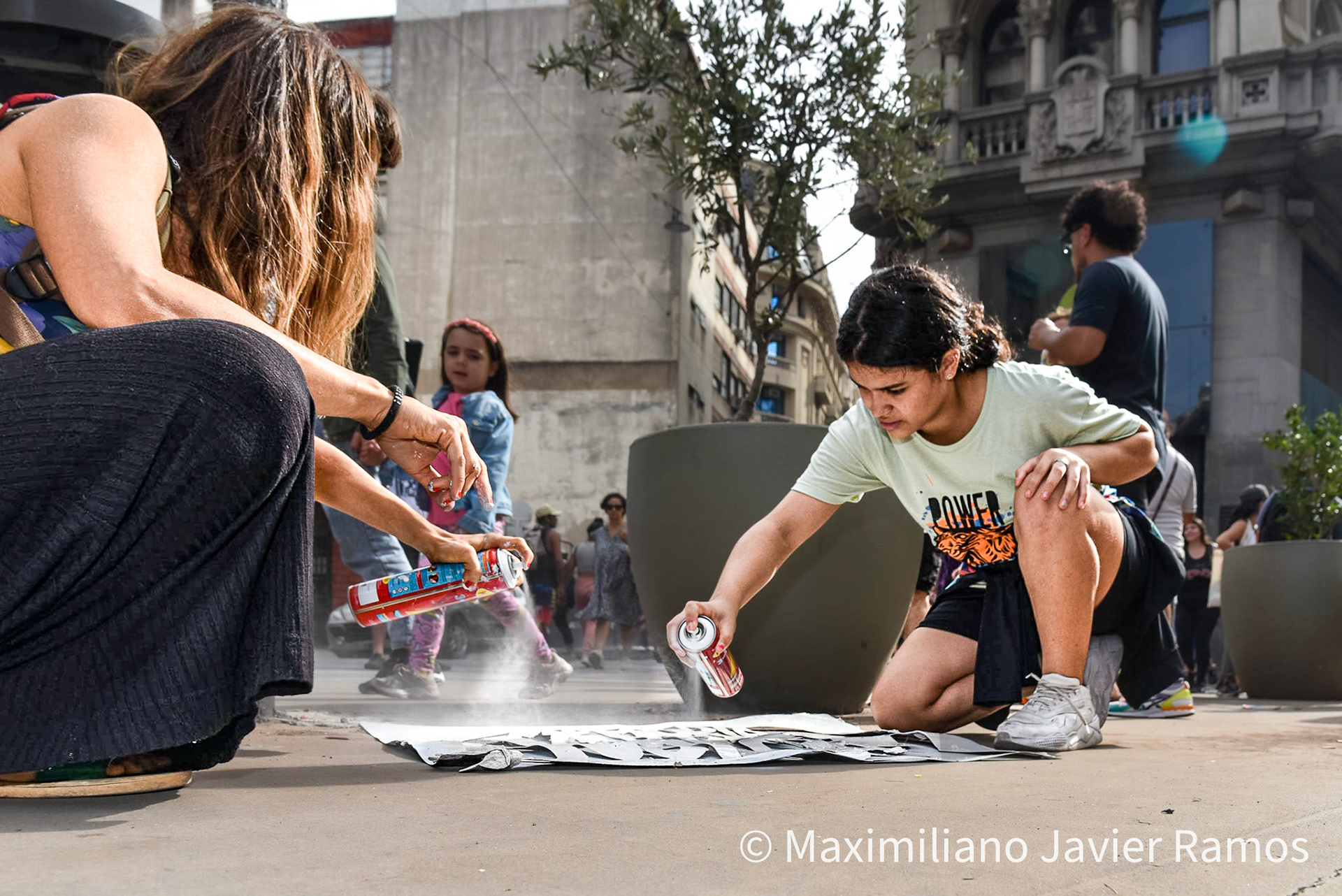 Dos mujeres jovenes pintan un graffiti durante la marcha por el día de la memoria. / Two young women paint graffiti during the Memorial Day march. / El Día Nacional de la Memoria por la Verdad y la Justicia es un día feriado inamovible de Argentina que se conmemora cada 24 de marzo. La fecha remite al golpe de Estado del 24 de marzo de 1976 y busca generar memoria y conciencia colectiva para que los golpes de Estado y las violaciones de derechos humanos no se repitan "nunca más" y sus autores sean enjuiciados y castigados. El Proceso de Reorganización Nacional fue una dictadura cívico-militar que causó que decenas de miles de personas fueran asesinadas, desaparecidas, violadas, torturadas, secuestradas siendo bebés, o debieran nacer en cautiverio, padecer la sustracción de su identidad y sufrir el exilio. Las organizaciones de derechos humanos, los sindicatos, el movimiento estudiantil, los movimientos sociales y muchos partidos políticos hacen referencia a los 30 000 desaparecidos,1 que fueron víctimas de la última dictadura y cuya presencia en la sociedad actual se invoca en cada conmemoración al grito “30.000 detenidos-desaparecidos ¡Presentes! ¡Ahora y siempre!” / The National Day of Memory for Truth and Justice is an immovable holiday in Argentina that is commemorated every March 24. The date refers to the coup d'état of March 24, 1976 and seeks to generate memory and collective awareness so that coups d'état and human rights violations are not repeated "never again" and their perpetrators are prosecuted and punished. The National Reorganization Process was a civil-military dictatorship that caused tens of thousands of people to be killed, disappeared, raped, tortured, kidnapped as babies, or had to be born in captivity, suffer theft of their identity and suffer exile. Human rights organizations, trade unions, the student movement, social movements and many political parties refer to the 30,000 disappeared,1 who were victims of the last dictatorship and whose presence in today's society is invoked in every shouted commemoration “30,000 detained-disappeared Present! Now and always!"