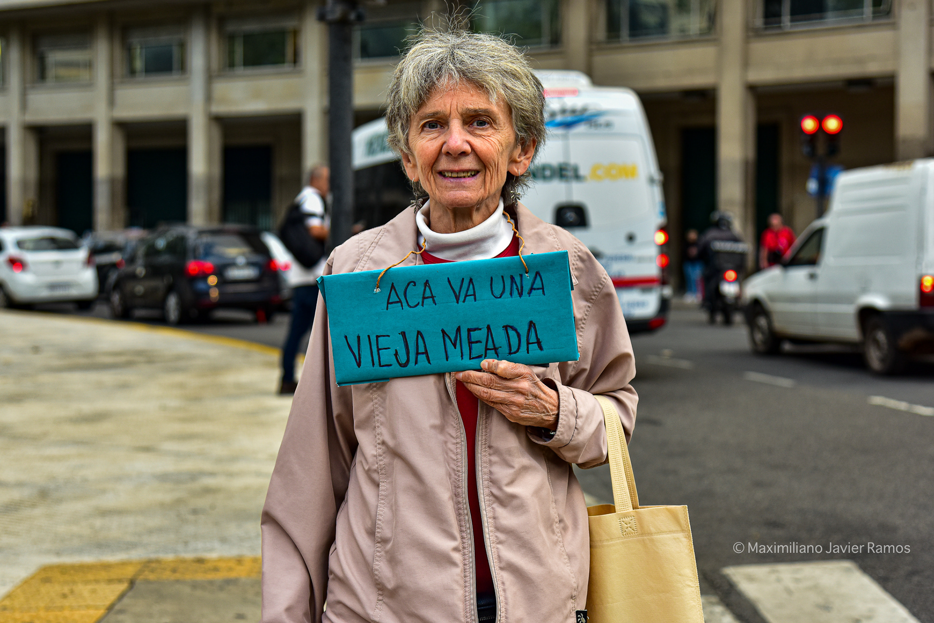 Una jubilada cerca de la Plaza de Mayo, sostiene un cartel que dice: "Acá va una vieja meada". // A retired woman near Plaza de Mayo, holding a sign that reads "Here goes a peeing old woman."