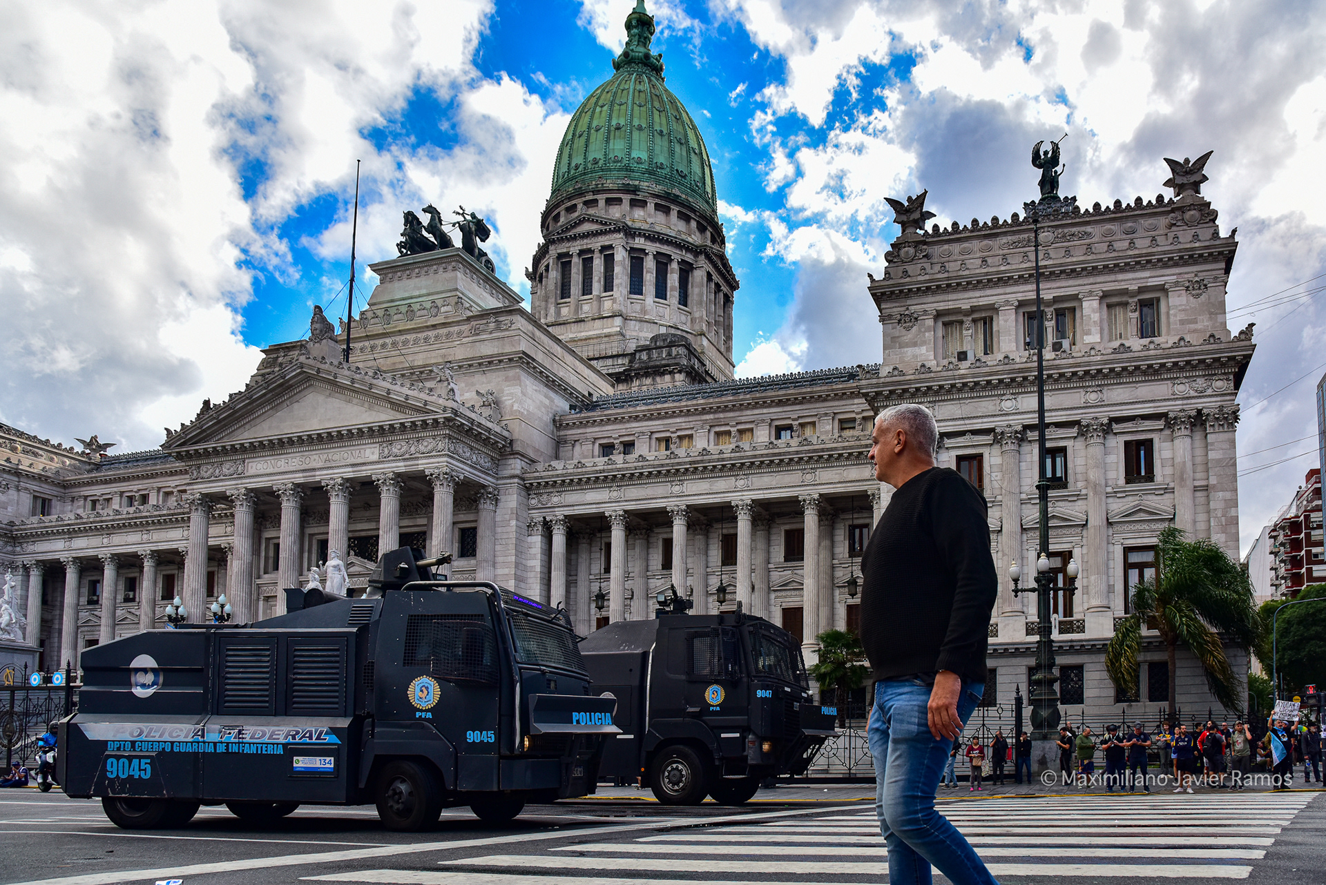 Un hombre cruza la avenida frente al Congreso Nacional frente a dos cañones de agua de la policía federal utilizados durante la manifestación. // A man crosses the avenue in front of the National Congress in front of two federal police water cannons used during the demonstration.