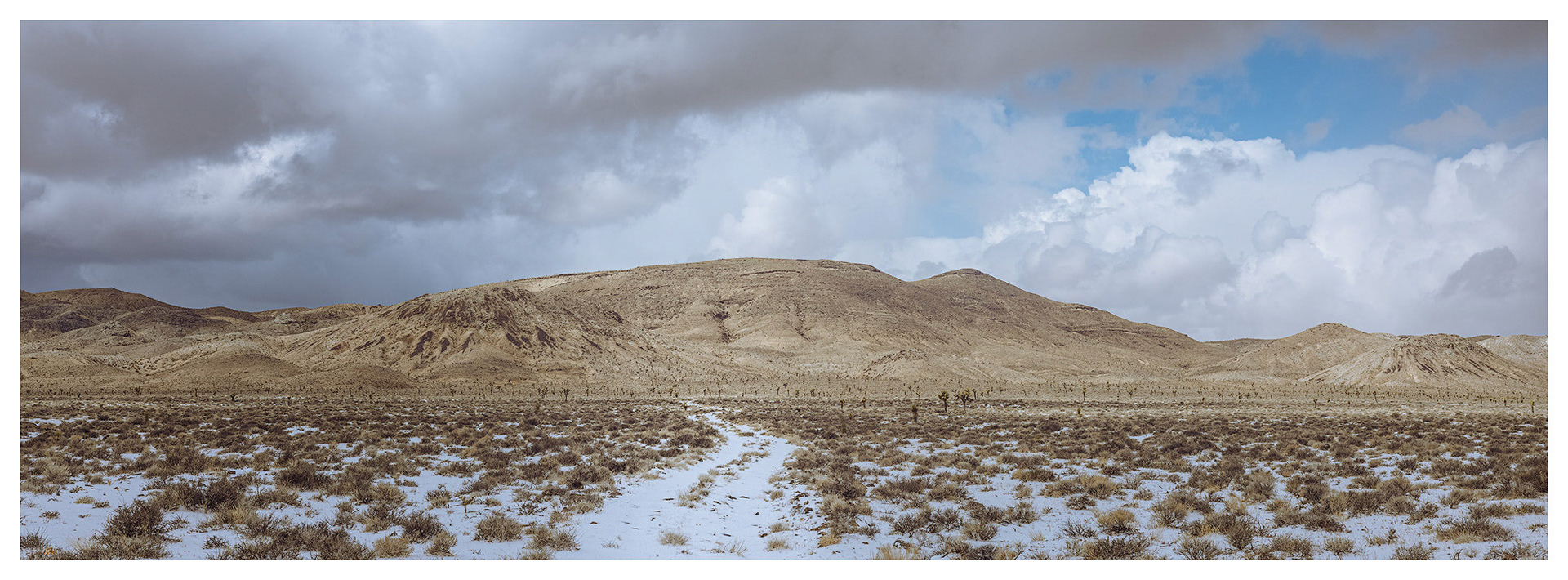 Left the truck in the turbidity of the graupel squall to walk a two-track to the slopes; summit high point on the right.