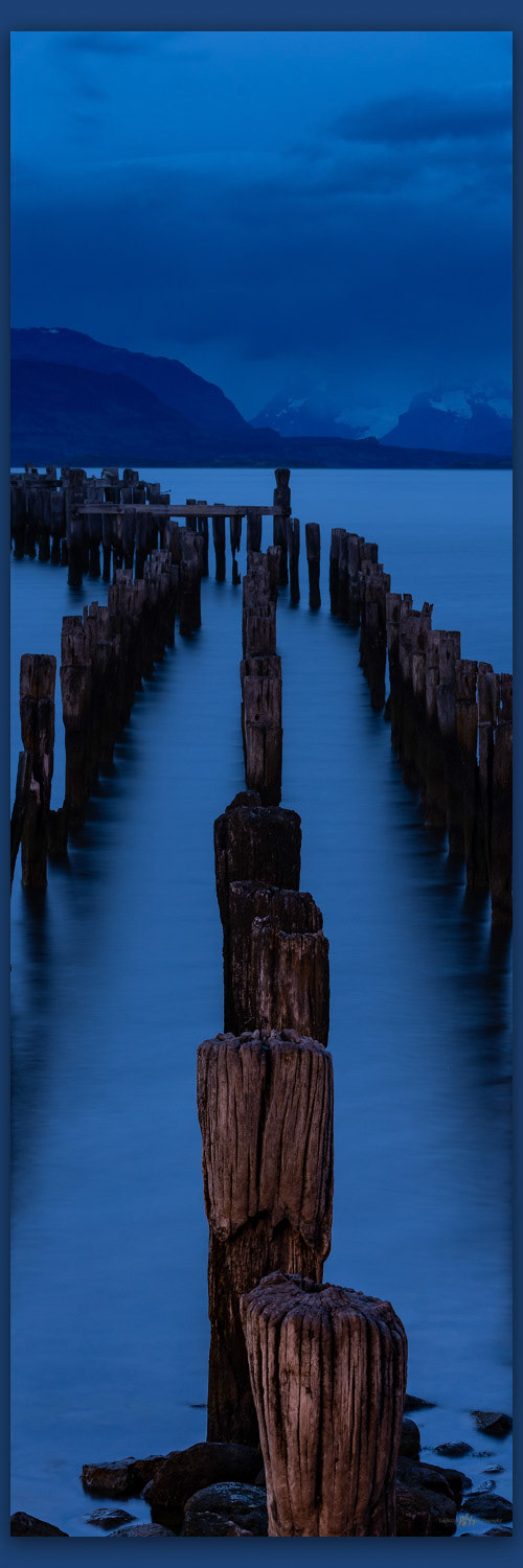 Short walk, long pier. Pilings in the bay at Puerto Natalies, Patagonia, Chile