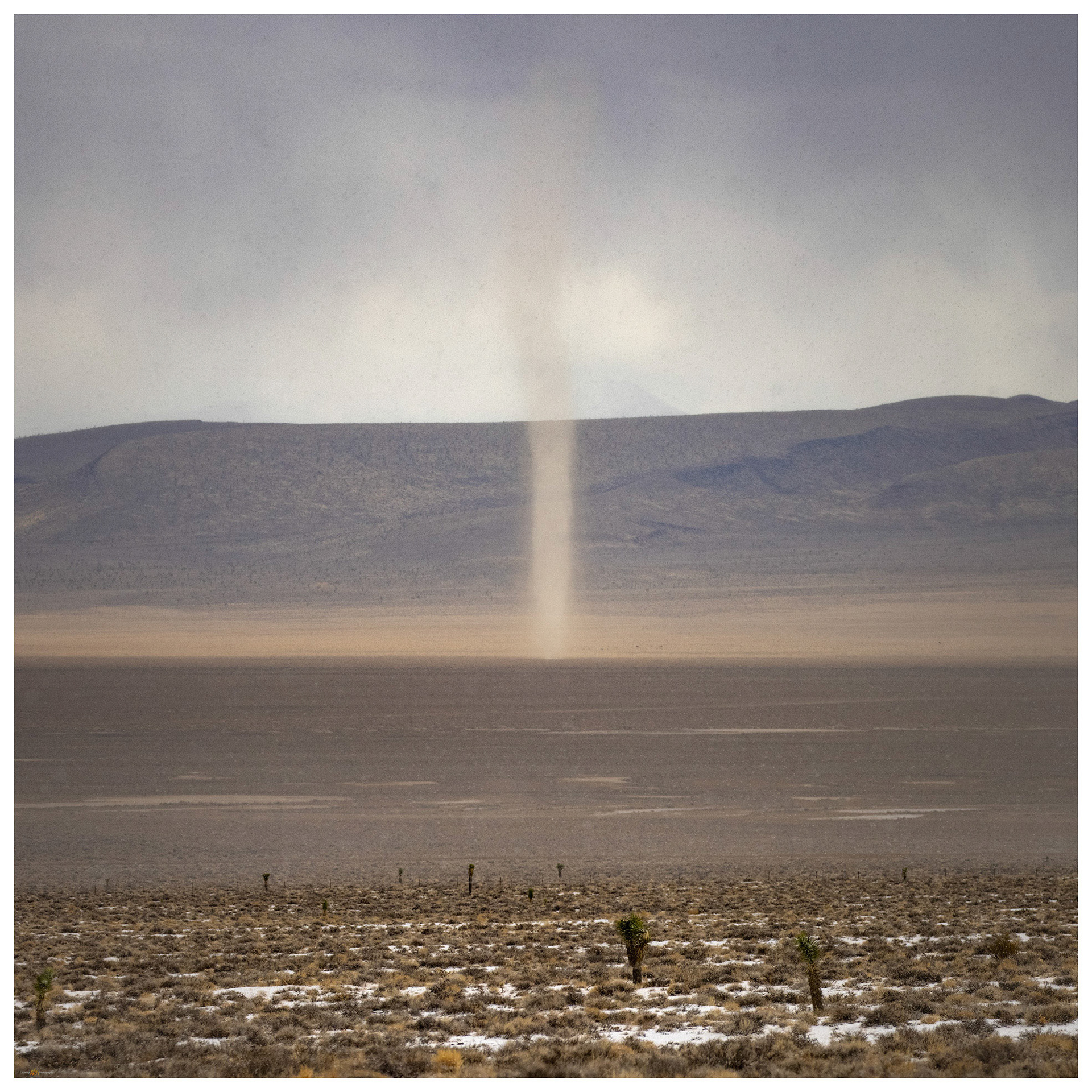 With snow building on the ground before me, I turned to see a dust devil approaching from the valley bottom.