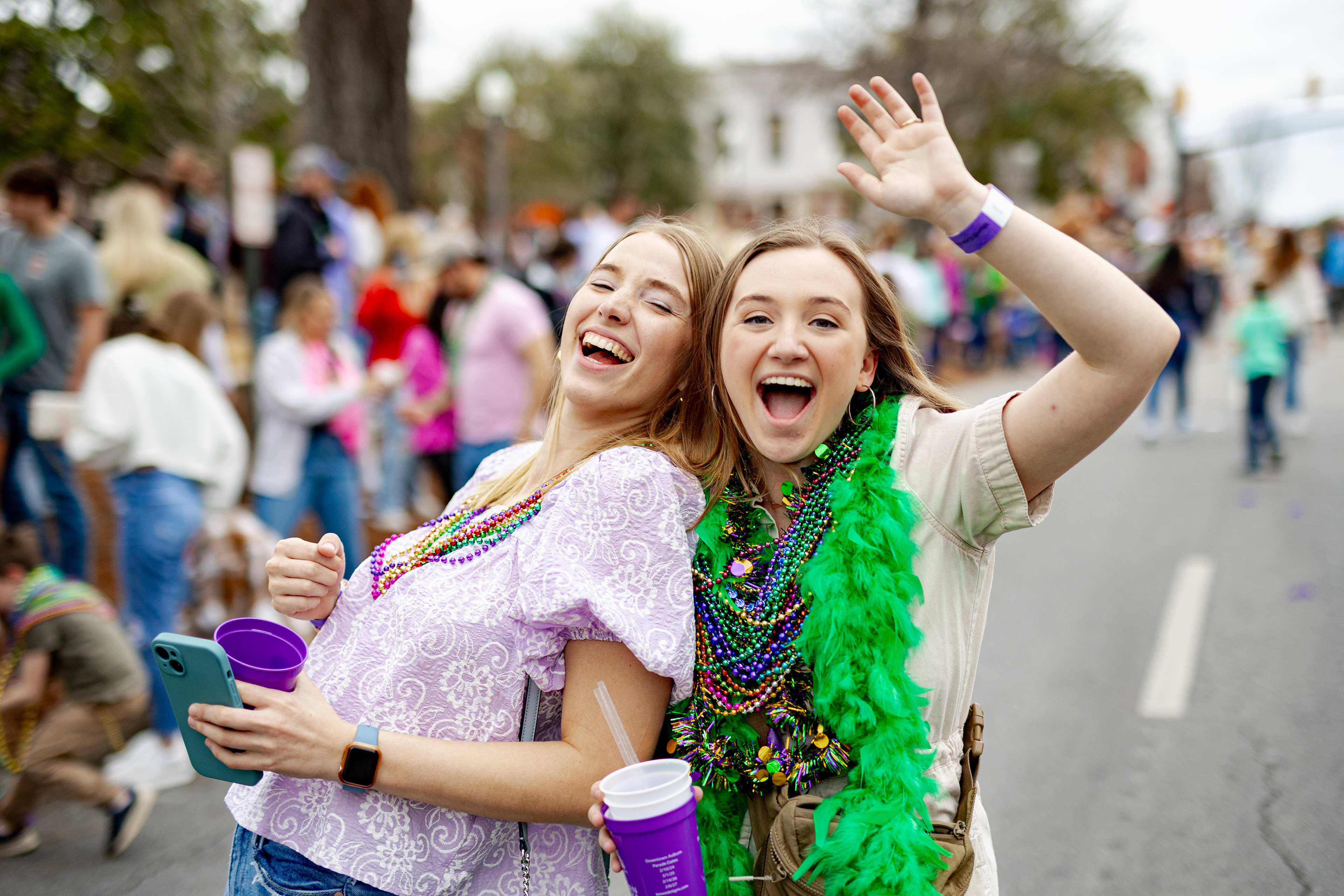 mardi gras parade in downtown auburn Alabama , two girls smiling and wearing beads