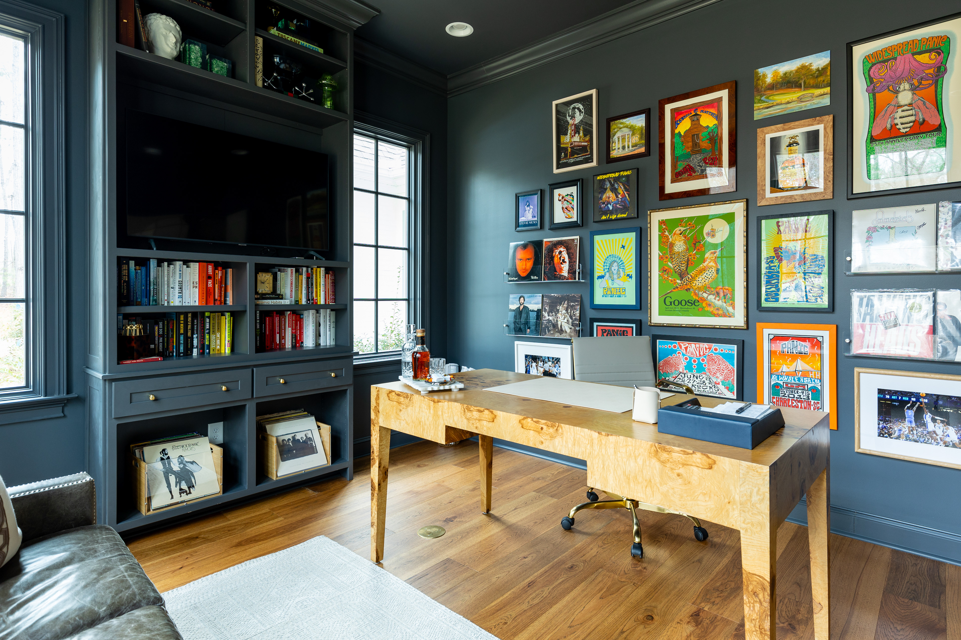 navy colored office with a bold and eclectic gallery wall with music and sports themed decor