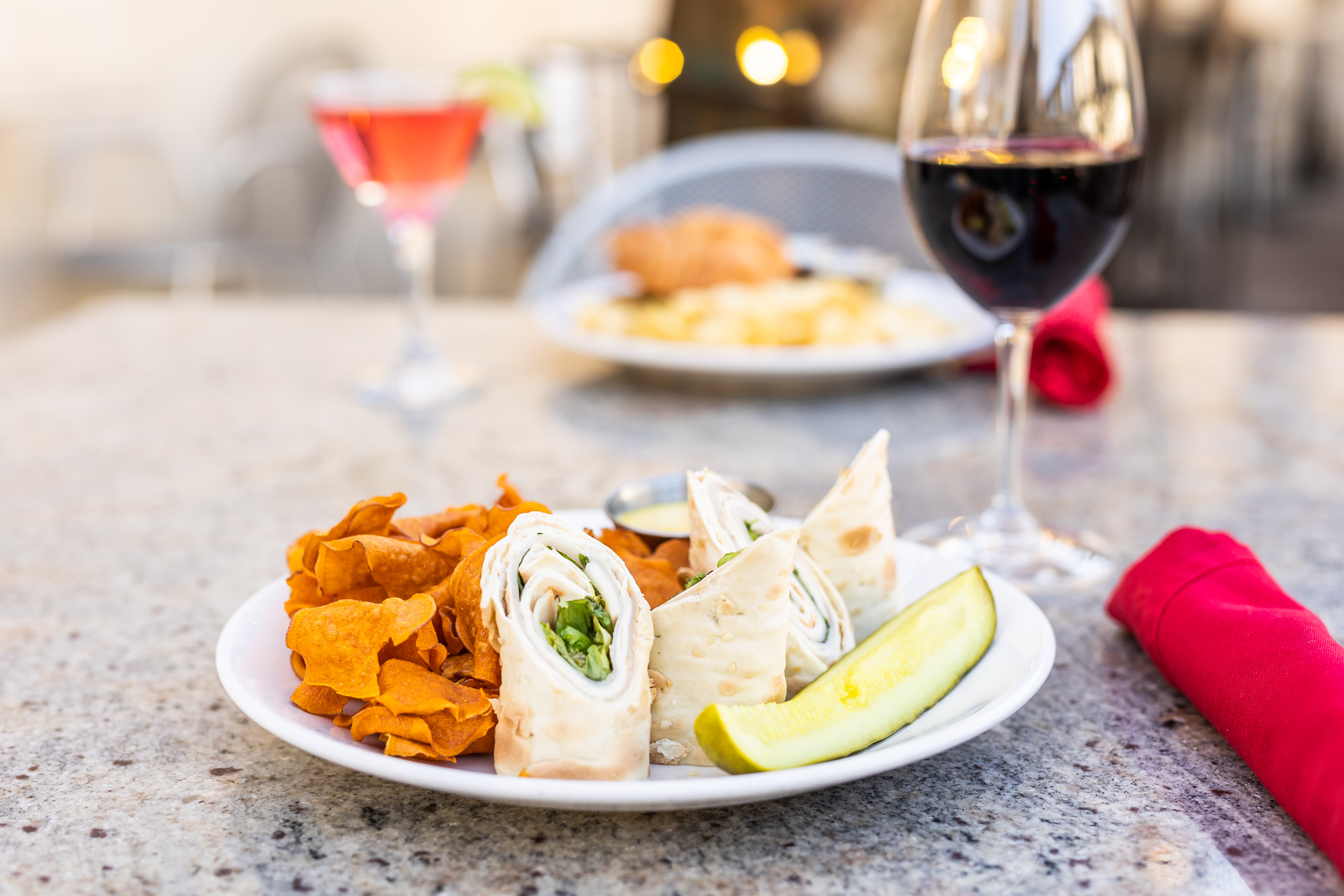a tight shot of lunch and wine at Amsterdam Cafe in Auburn Alabama, A turkey Wrap and sweet potato chips