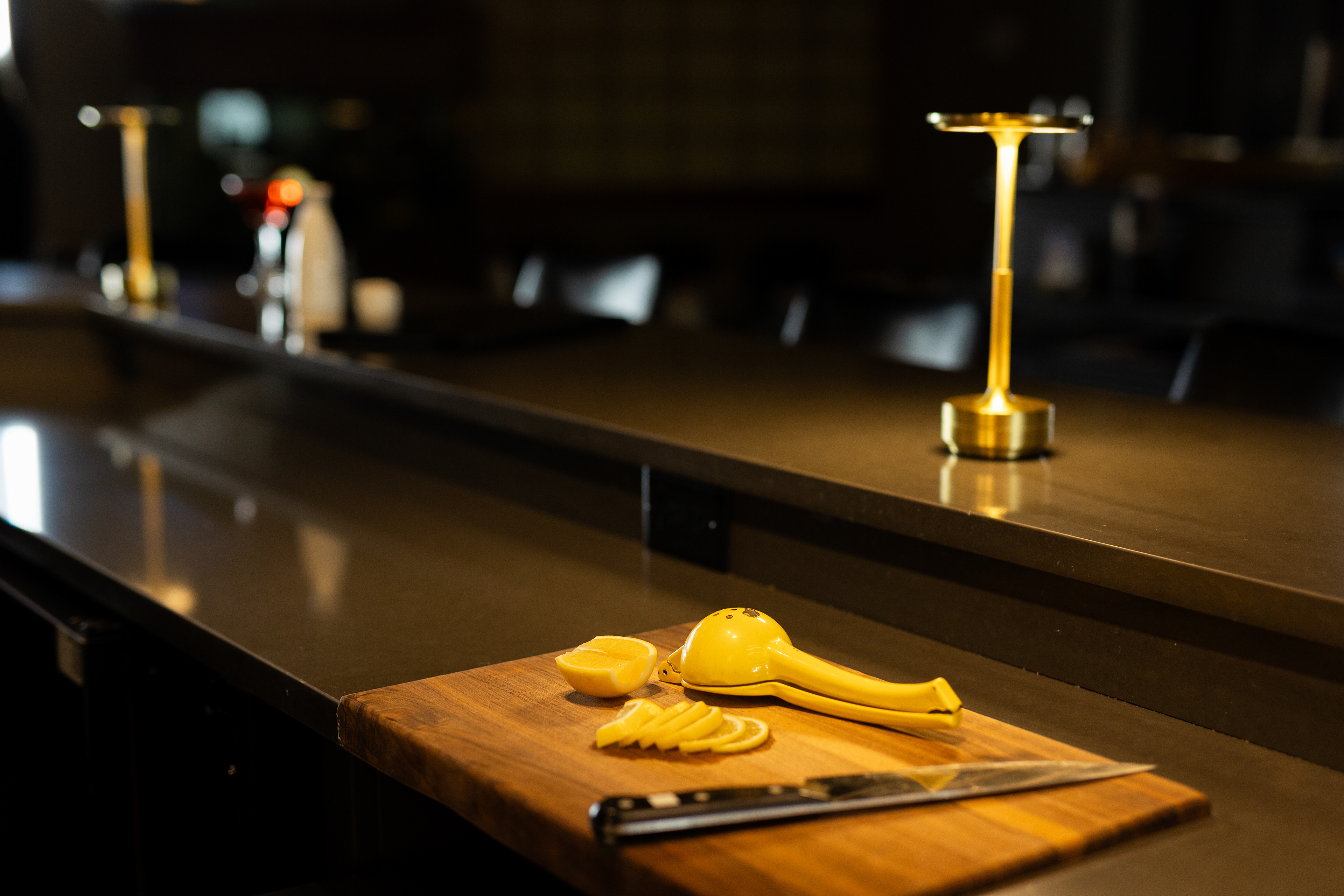 detail shots of a moody bar with lemons being prepped on the counter