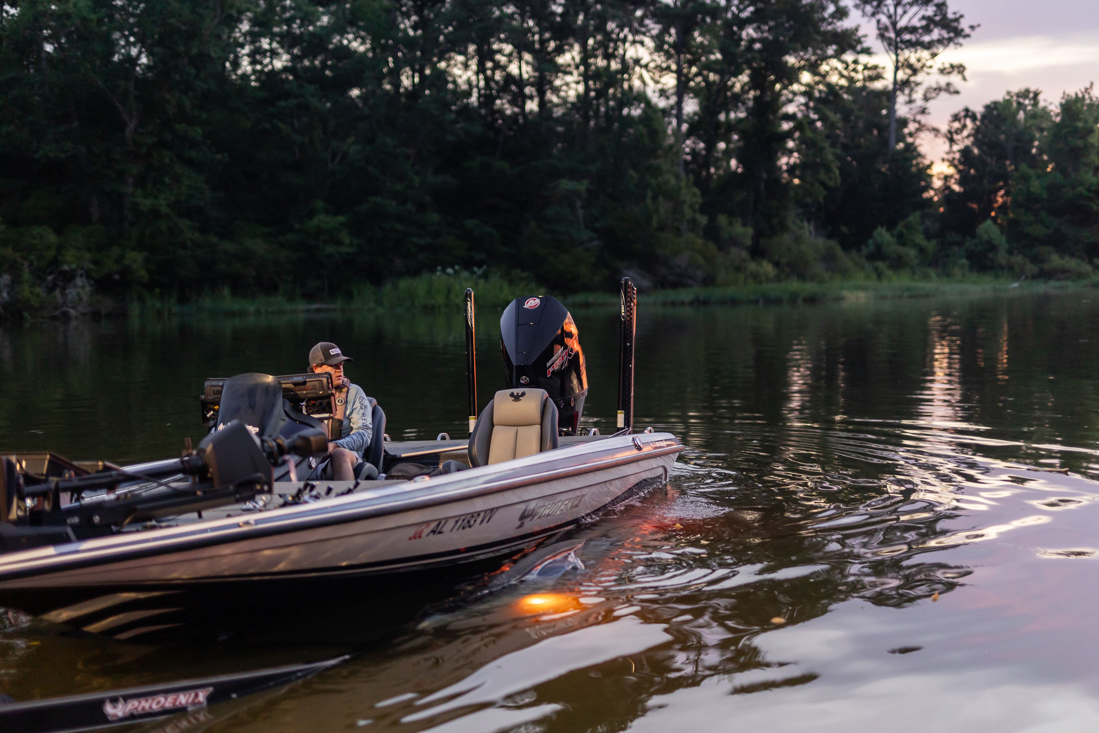 Bass Angler, Lucas Lindsey, reversing his boat off the ramp in Realtree Fishing Shirt and hat in the early morning around dusk