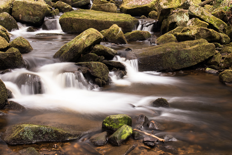Smoothed water cascading through the rocks in Padley Gorge in the Peak District.