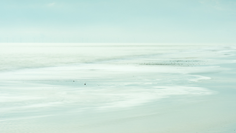 The incoming tide reflecting the sky on Winterton beach, Norfolk.