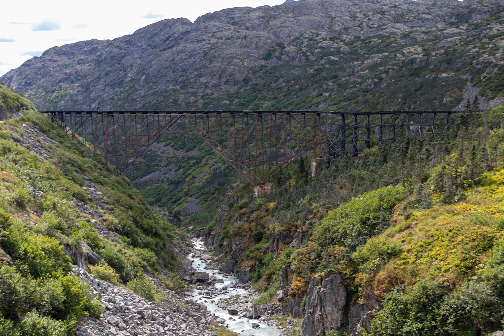 A final distant view of the dilapidated rail bridge after passing it..The way it is positioned adds a bit of a surprise as you approach the bridge, as you can't see the new bridge from the train until you are passing the old bridge.
