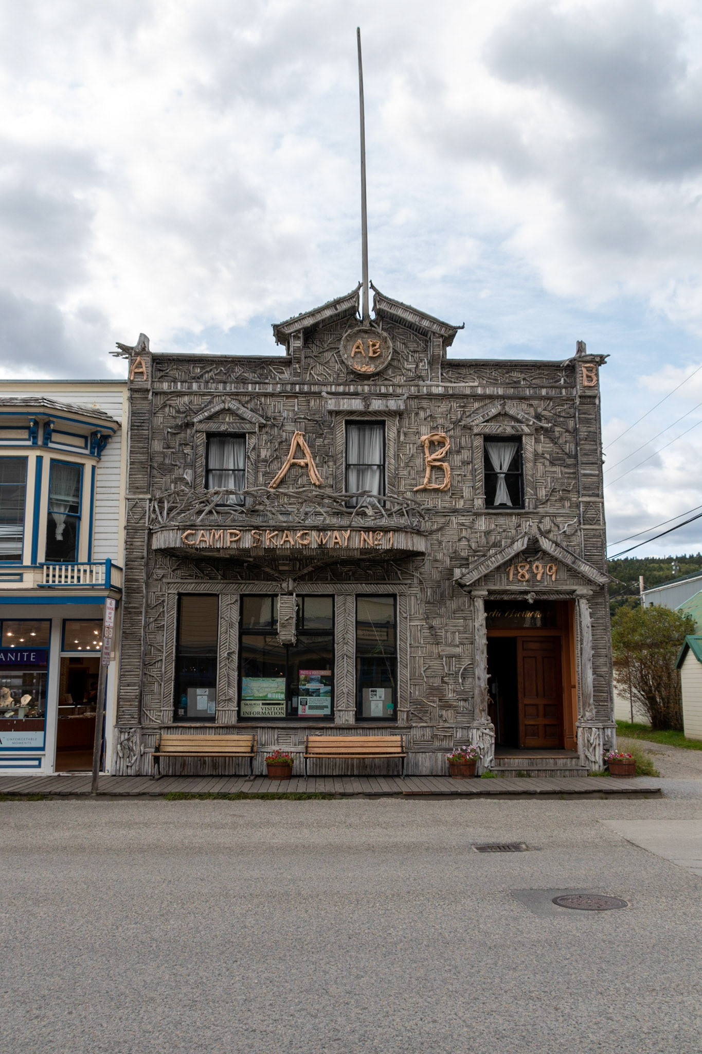 One of the most photographed buildings in Skagway, AK. In times past, it was a fraternal hall; the local chapter of the Brotherhood first met here in August 1899. You'll notice the letters "A.B." and the "1899" above the door, and "Camp Skagway No. 1" on the overhang. The organization's symbol, a gold pan and nuggets, is up near the roof line. The facade, which dates from 1900, has been called a prime example of Victorian Rustic Architecture. Charley Walker and his fellow lodge members collected over 8,800 driftwood sticks on the shores of Skagway Bay and nailed them to the front wall. The Brotherhood, which remained active into the 1920s, once entertained President Warren G. Harding. The building is currently the home of the Visitor Information Center operated by the Skagway Convention & Visitors Bureau.
The outside facade of the Arctic Brotherhood Hall underwent a restoration during the winter of 2004-2005. All of the 8,883 pieces of driftwood on the front of the building were removed. Forty percent (3,533) had rotted and were replaced, while sixty percent (5,300) were still able to be preserved over one hundred years later.