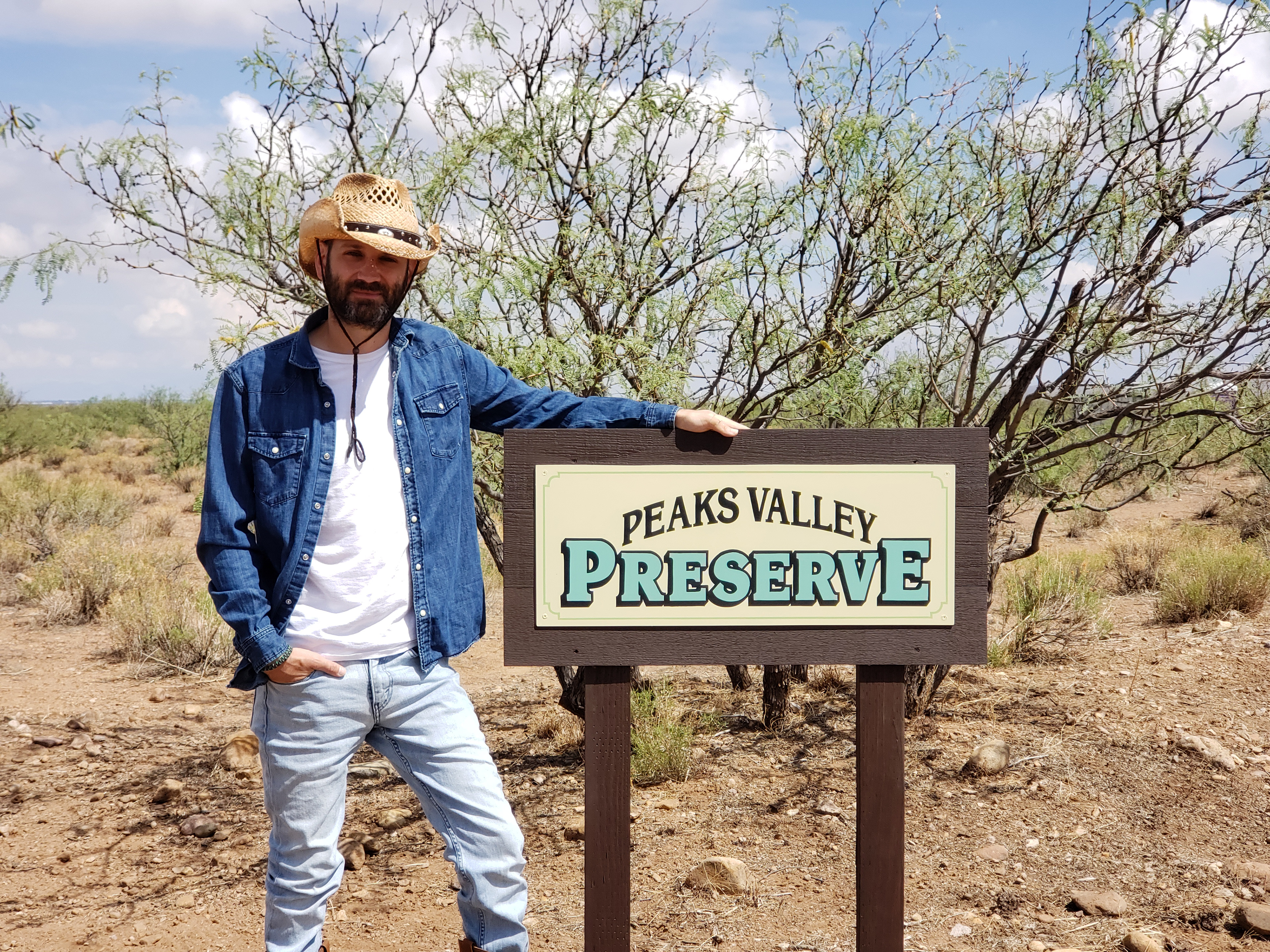 Peaks Valley Preserve owner Michael Willford standing next to the Peaks Valley Preserve sign.