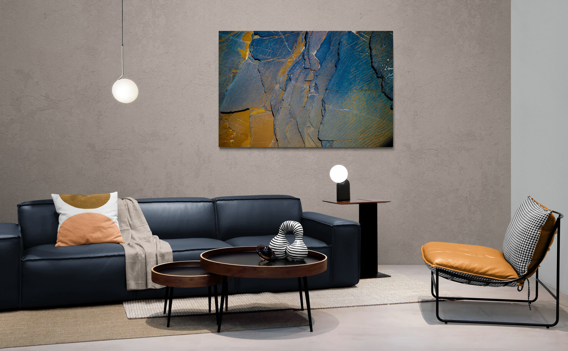 An abstract photo of textured rocks looks almost three dimensional hanging on the wall of a modern living room.
