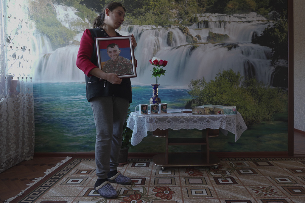 Minara Gabrielyan, daughter-in-law of local resident Lenser Gabrielyan, holds a portrait of her brother, who was killed in combat the same night when the peace deal between Armenia and Azerbaijan was agreed, as she stands in her home in the village of Taghavard in the region of Nagorno-Karabakh, January 11, 2021. REUTERS/Artem Mikryukov