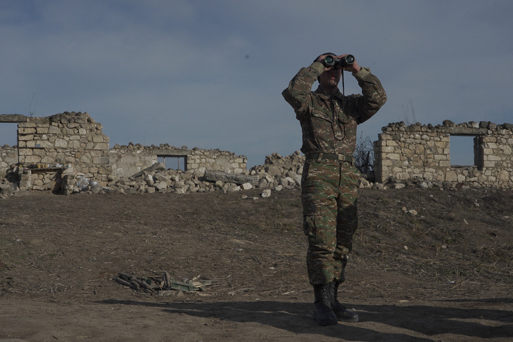 An ethnic Armenian soldier looks through binoculars as he stands at fighting positions near the village of Taghavard in the region of Nagorno-Karabakh, January 11, 2021. REUTERS/Artem Mikryukov