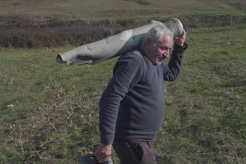 Local resident Lenser Gabrielyan, 65, carries fragments of exploded shells in his field near the village of Taghavard in the region of Nagorno-Karabakh, January 11, 2021. Following the military conflict over Nagorno-Karabakh and a further signing of a ceasefire deal, the village was divided into two parts: the Azeri forces stayed in the upper western end and those ethnic Armenians who did not flee live now in the east, reinforced by armed units. Picture taken January 11, 2021. REUTERS/Artem Mikryukov