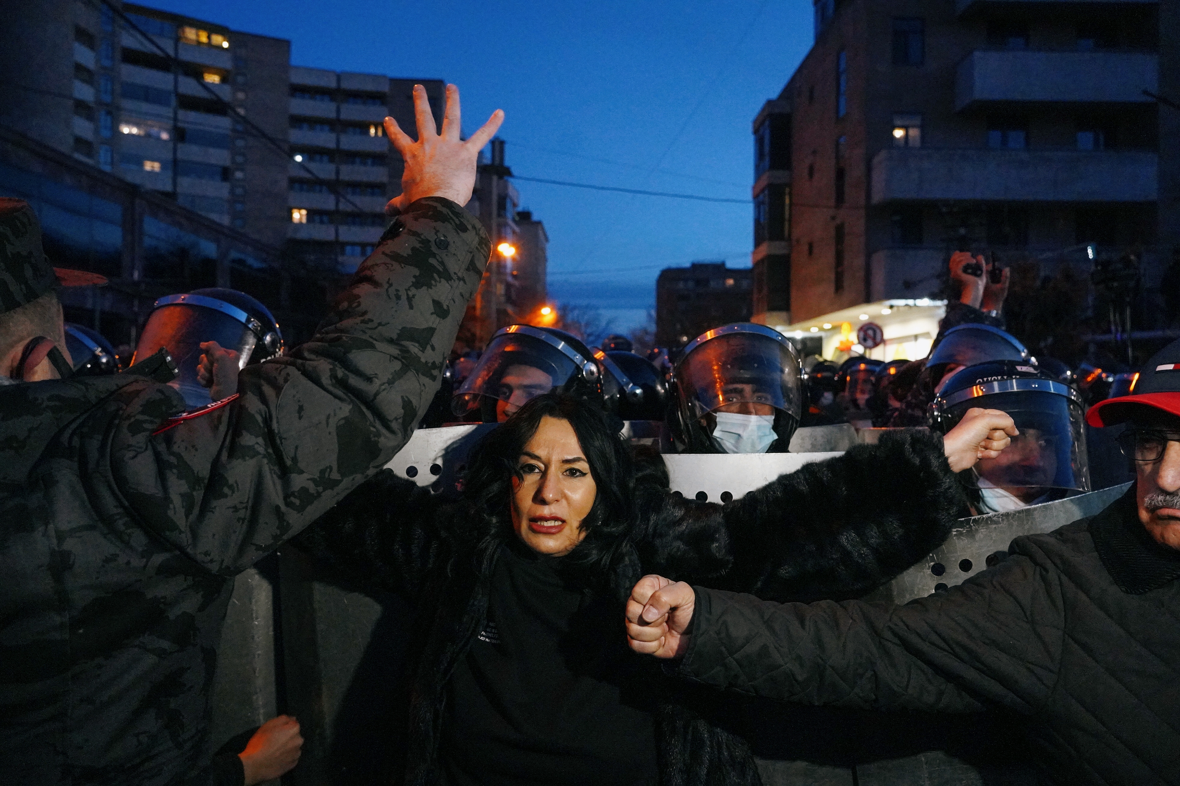 People gather near law enforcement officers, who stand guard during an opposition rally to demand the resignation of Armenian Prime Minister Nikol Pashinyan in Yerevan, Armenia March 9, 2021. REUTERS/Artem Mikryukov