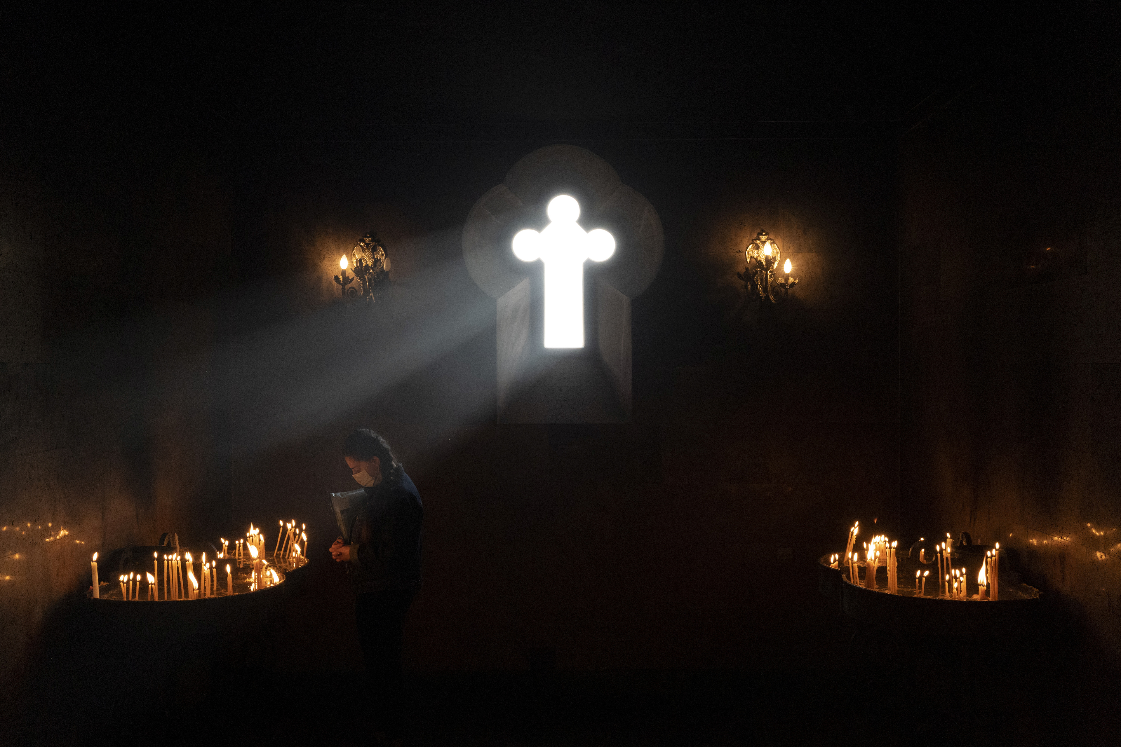 A believer wearing a protective face mask, used as a preventive measure against the spread of the coronavirus disease (COVID-19), prays inside the premises of a church in Yerevan, Armenia November 8, 2020. Picture taken November 8, 2020. REUTERS/Artem Mikryukov